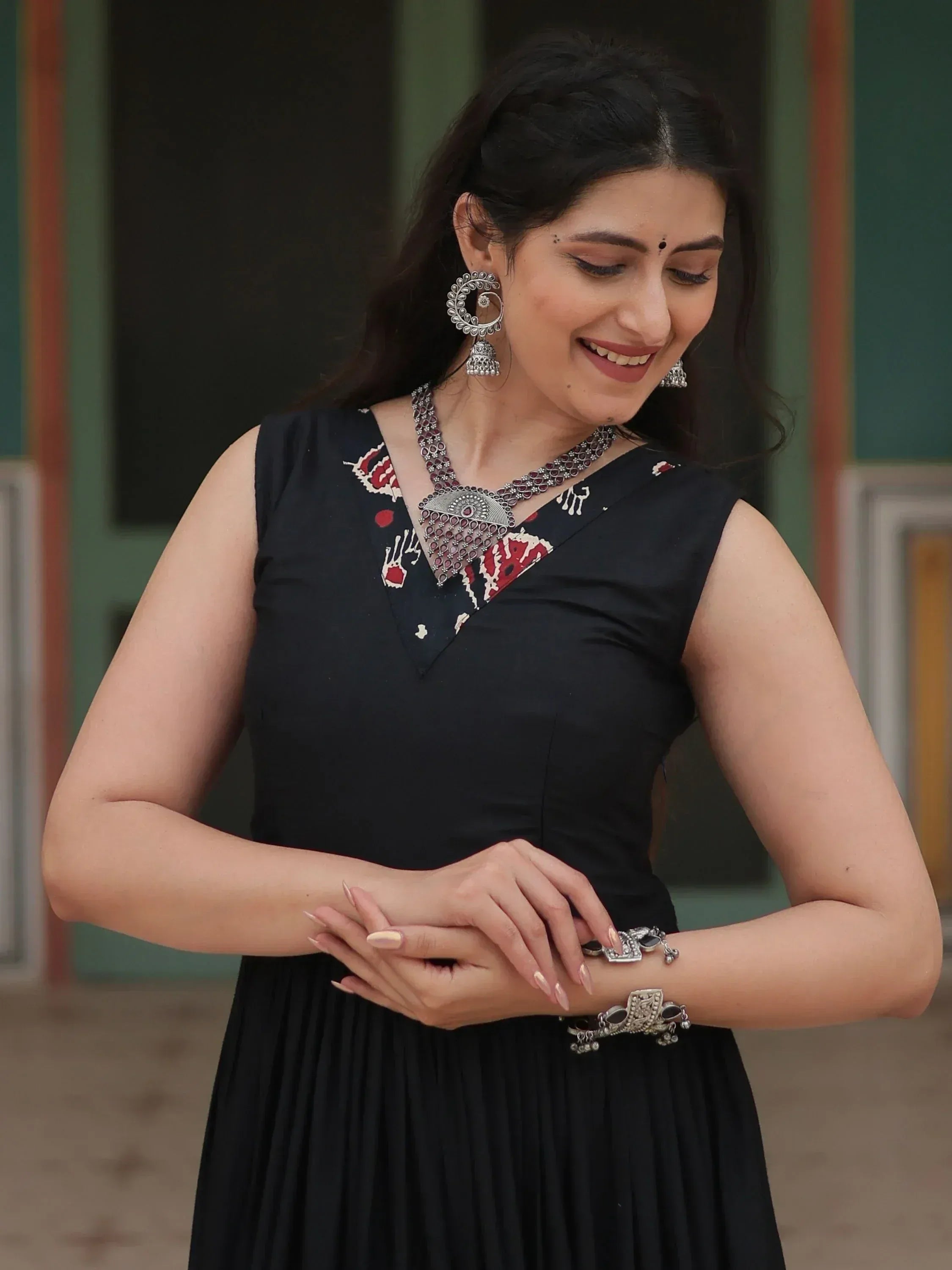 Woman in black ethnic gown with red white print, silver jewelry, perfect for Indian occasions