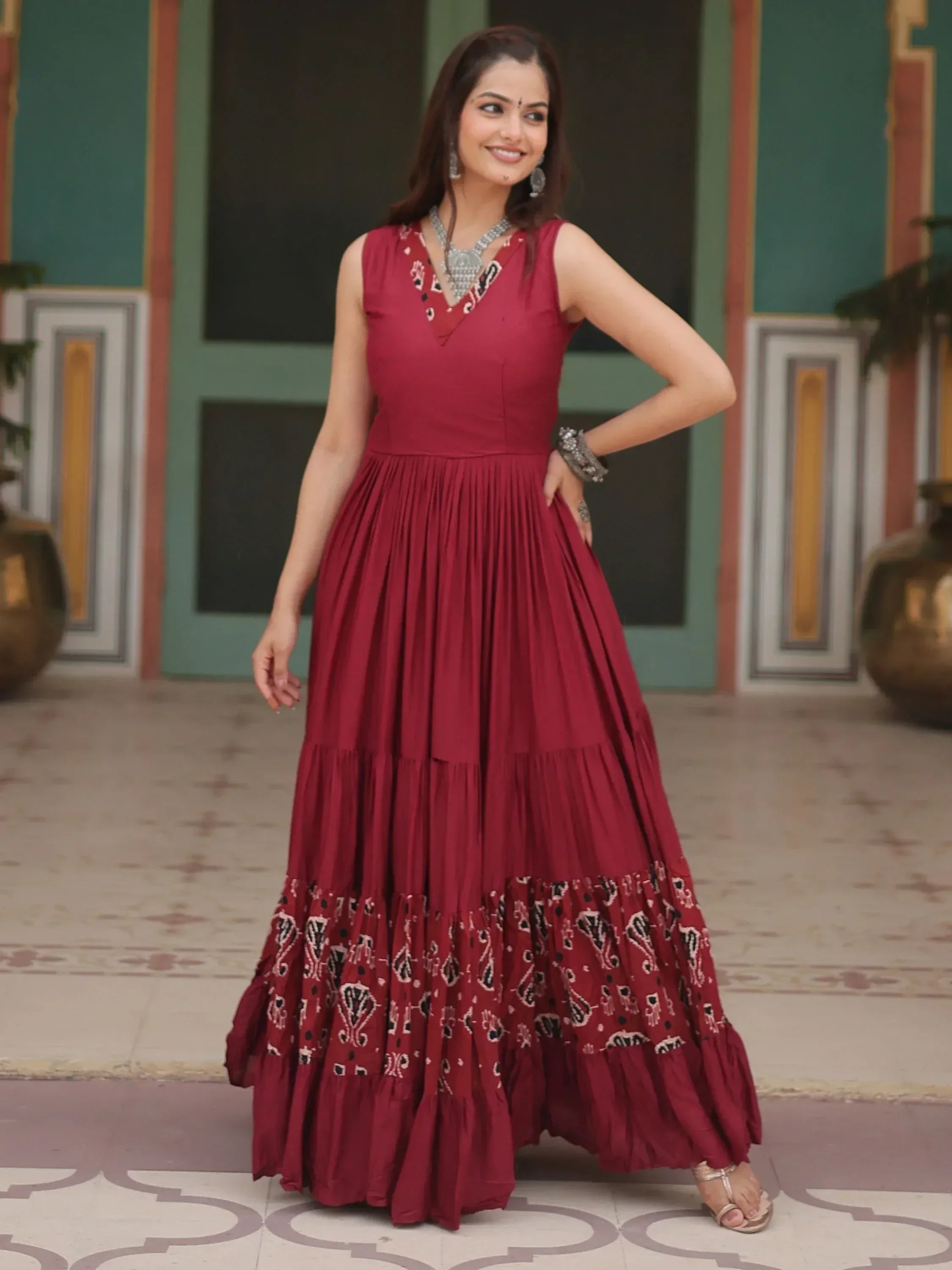 Maroon ethnic gown with printed tiered skirt, perfect for Indian festive occasions and weddings.