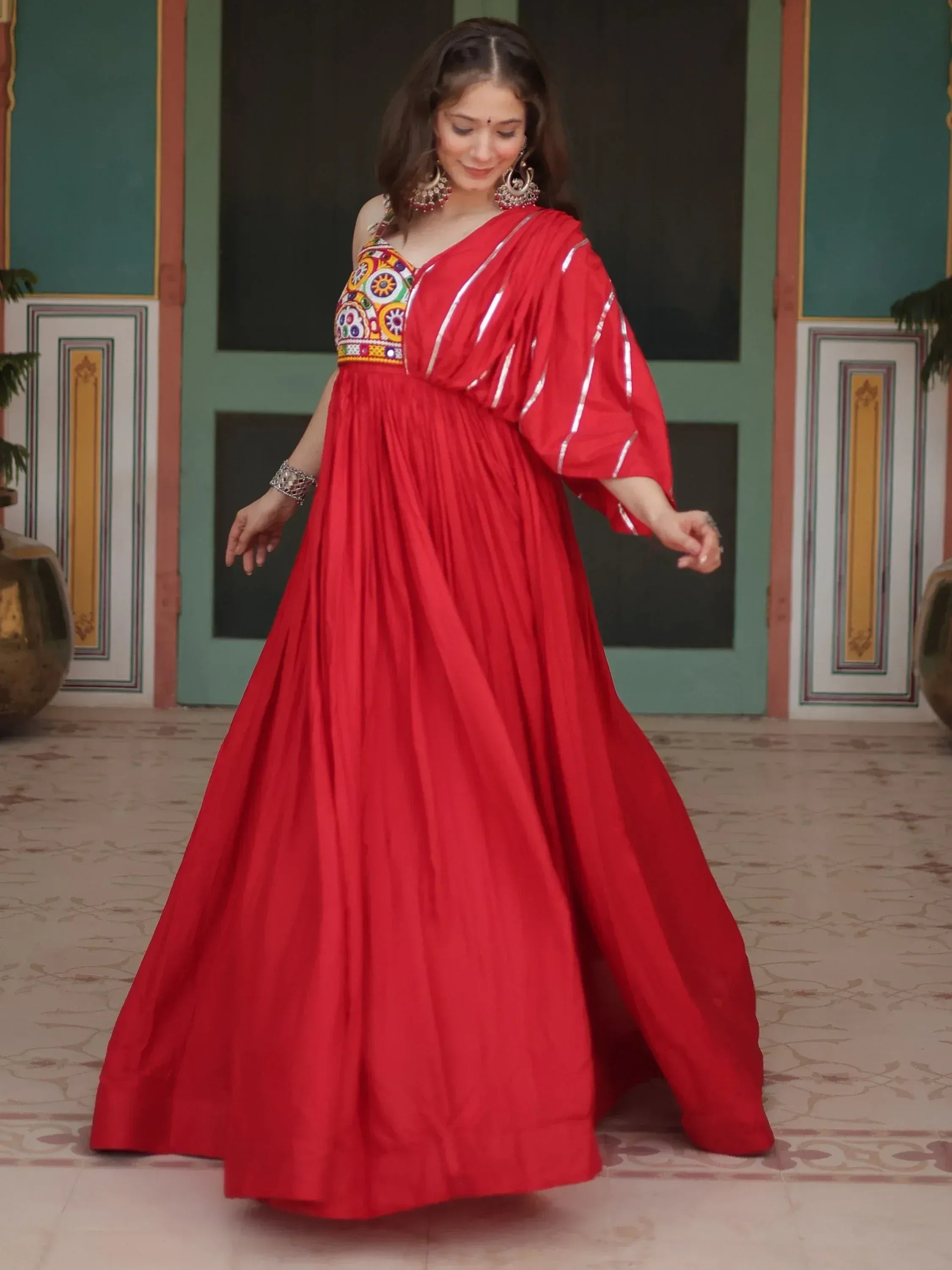 Red ethnic gown with colorful embroidery and silver stripes, perfect for Indian festive occasions