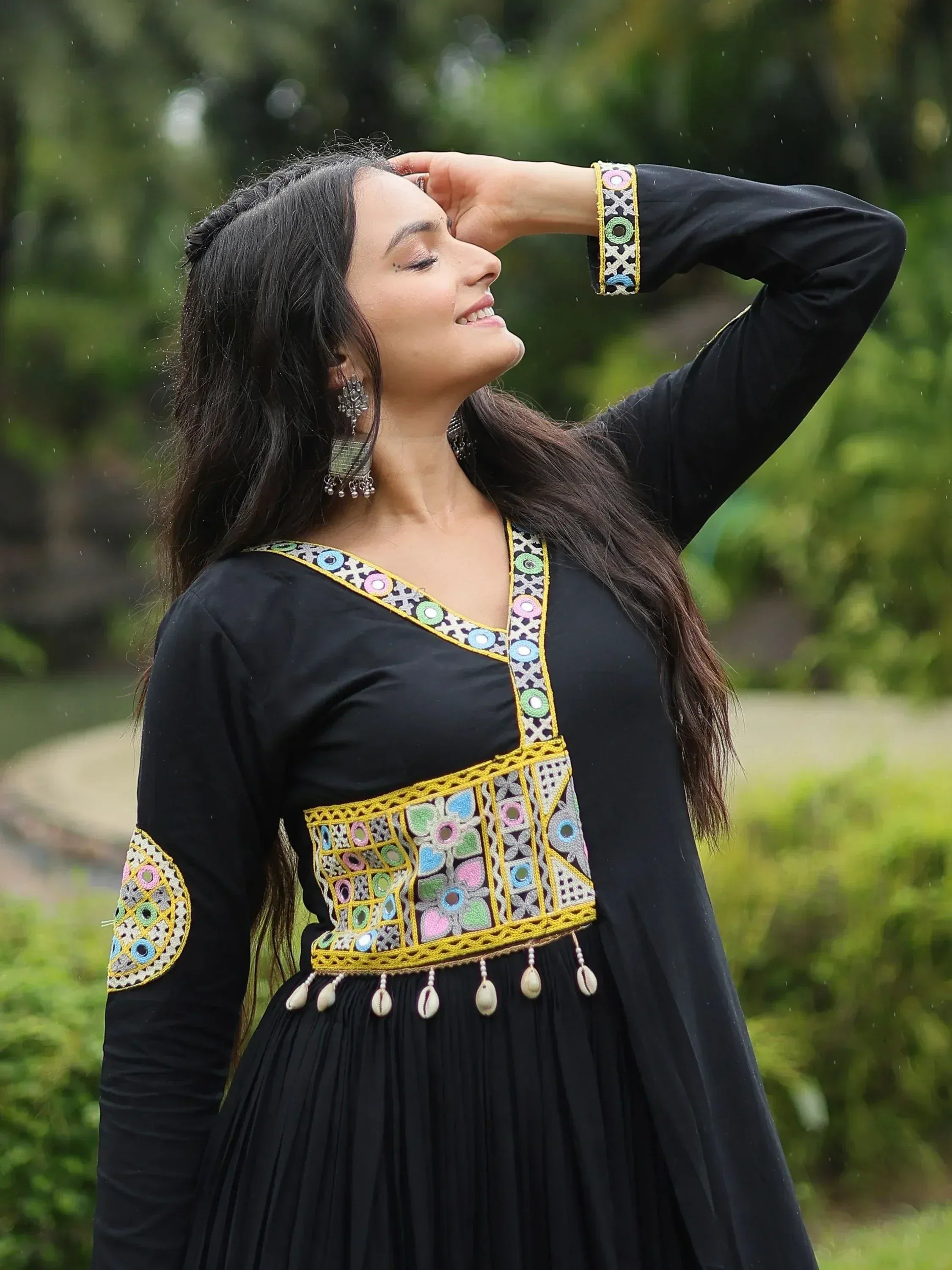Black ethnic gown with colorful mirror work and shell tassels, perfect for Indian festive wear