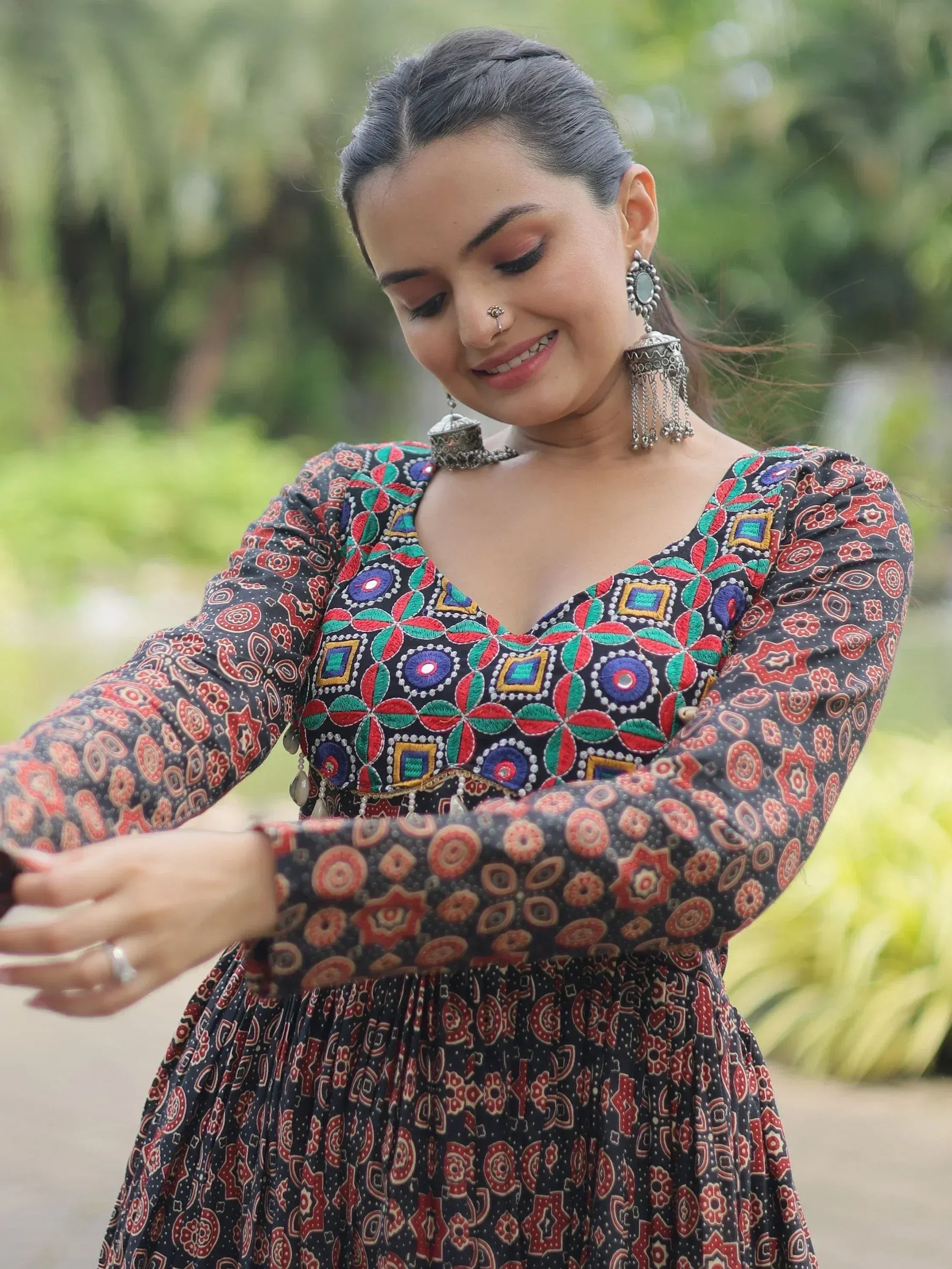 Woman in colorful embroidered ethnic gown with jhumka earrings, perfect for Indian occasions
