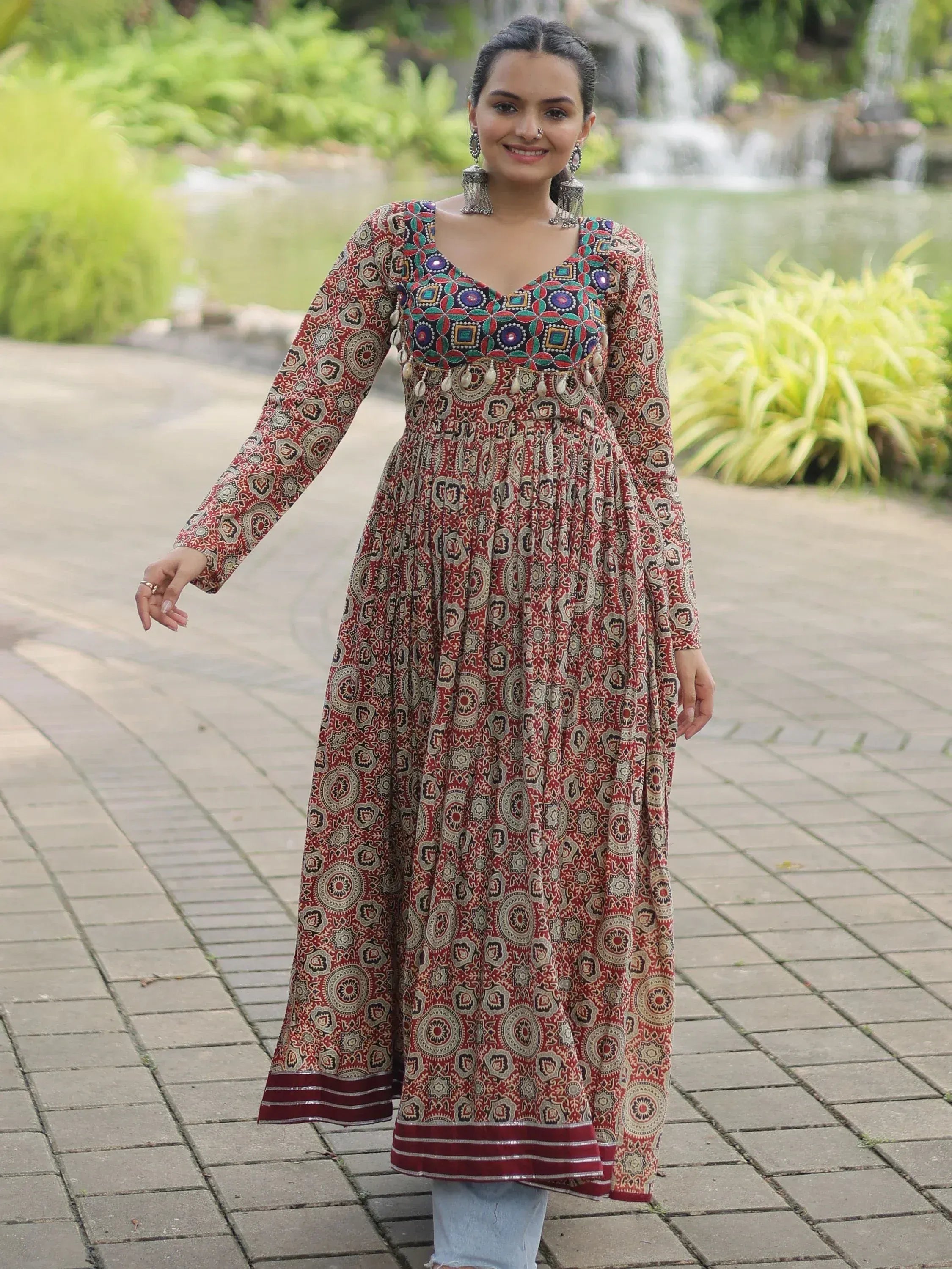 Woman in red printed ethnic gown with mirror work, perfect for Indian occasions and festivals