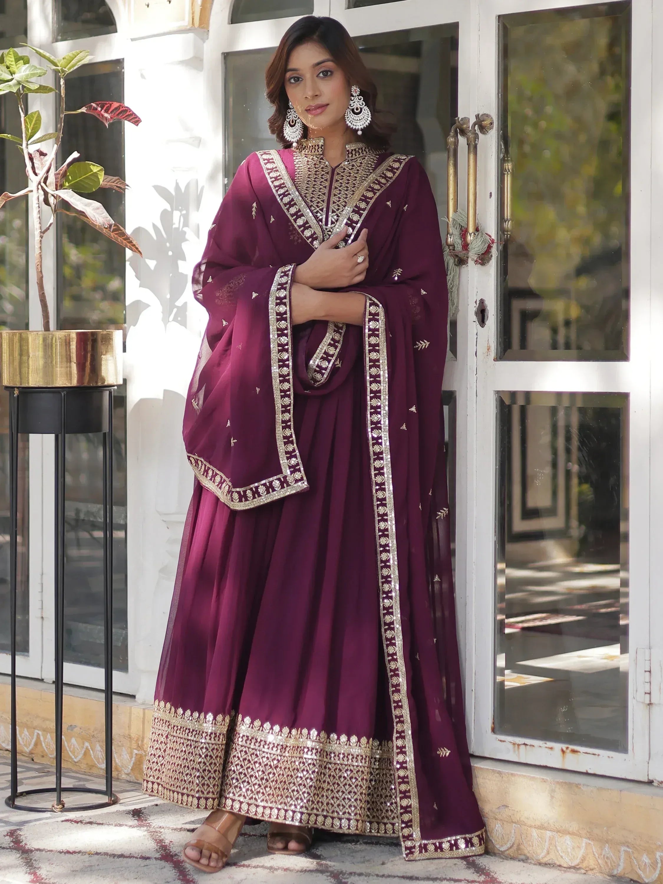 Elegant maroon ethnic gown with gold embroidery, perfect for Indian celebrations and events.