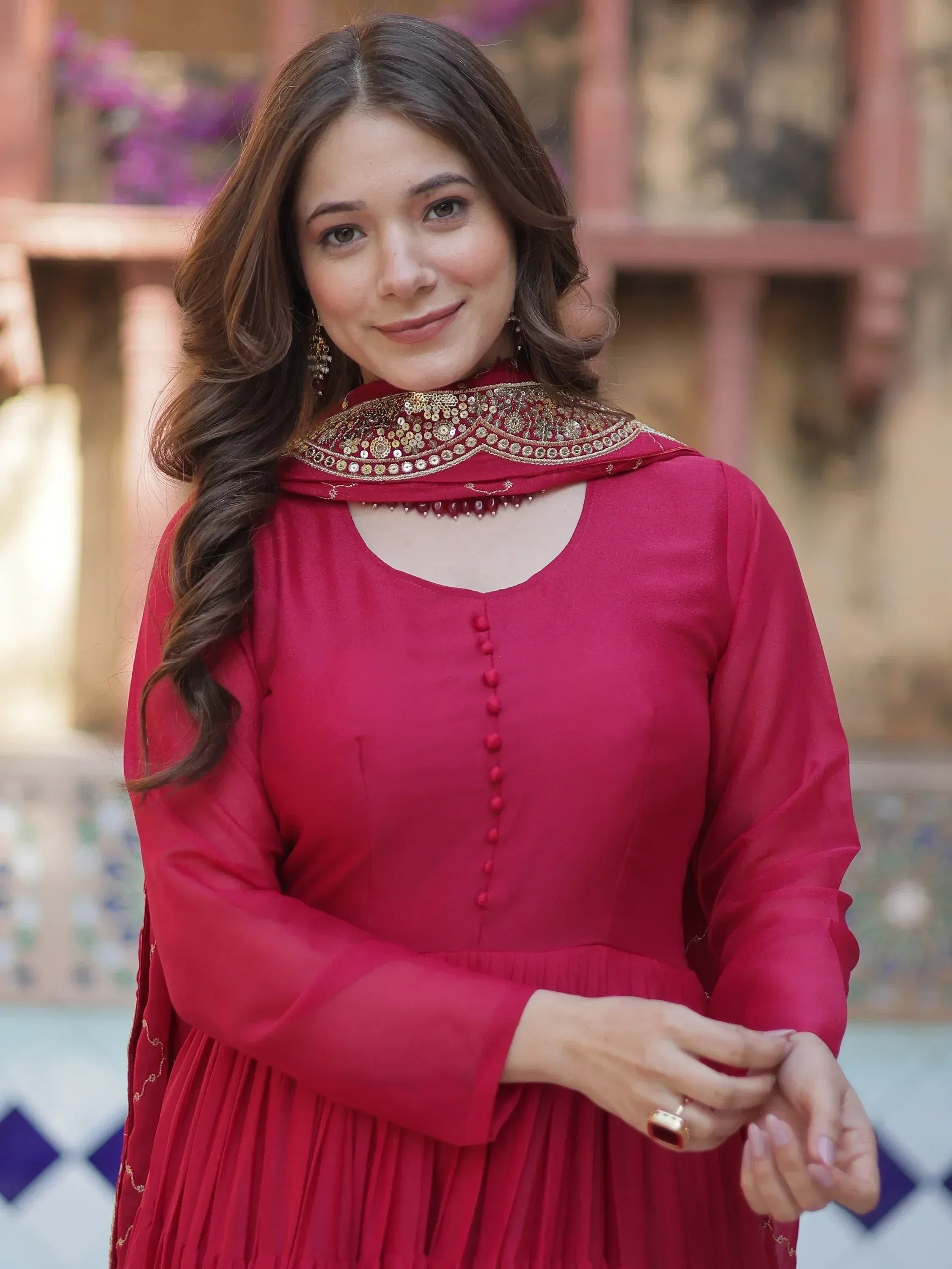 Woman in red ethnic gown with gold embroidery, perfect for Indian occasions and festive wear.