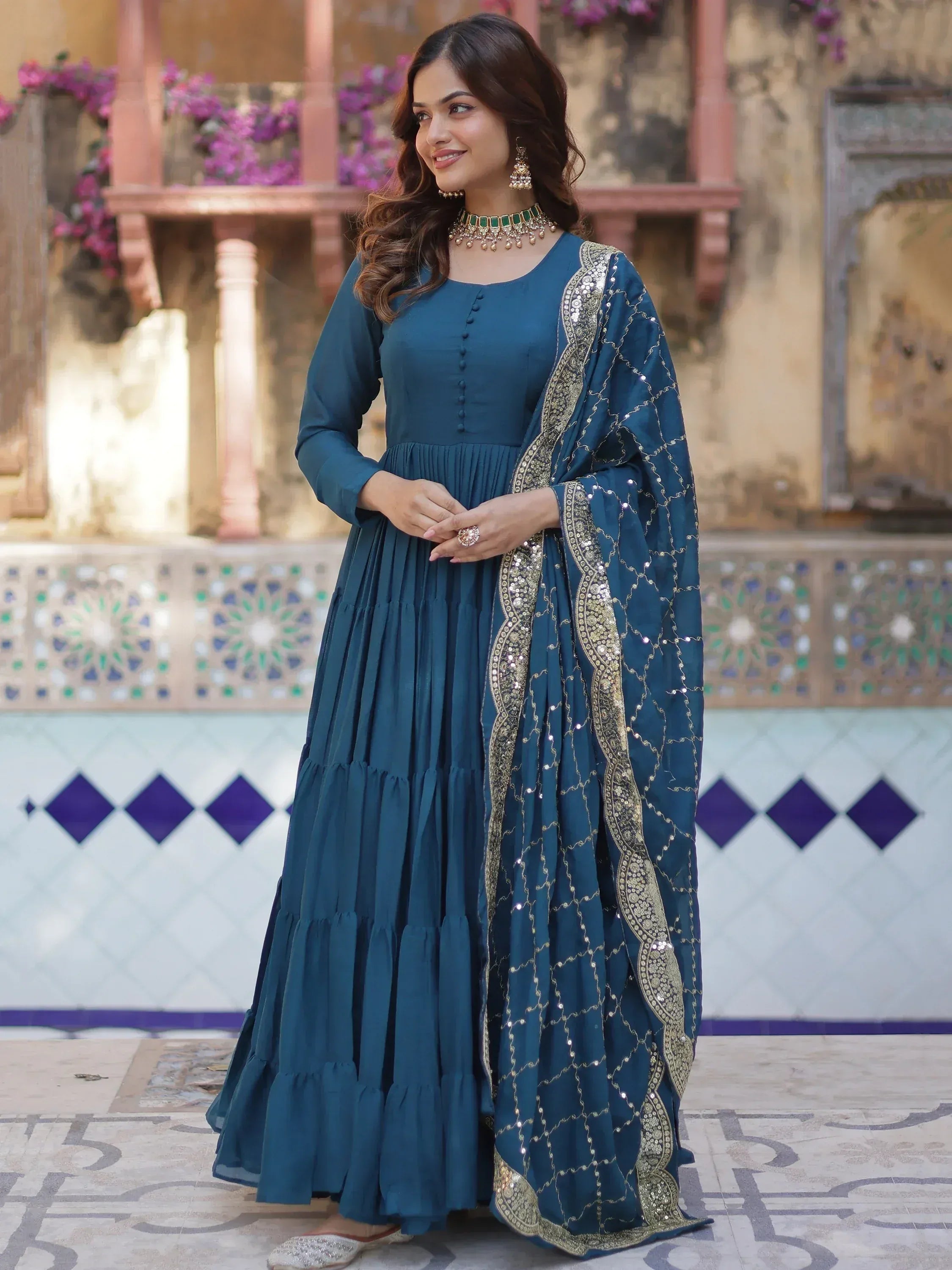 Teal blue ethnic gown with gold embroidery and sequins, perfect for Indian occasions