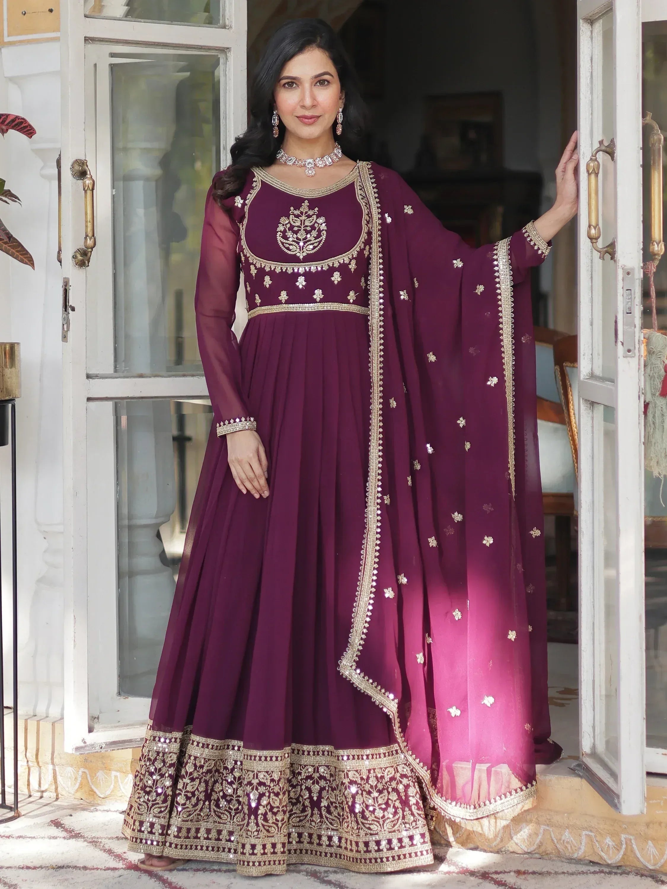 Elegant maroon ethnic gown with gold embroidery, perfect for Indian weddings and festive occasions.