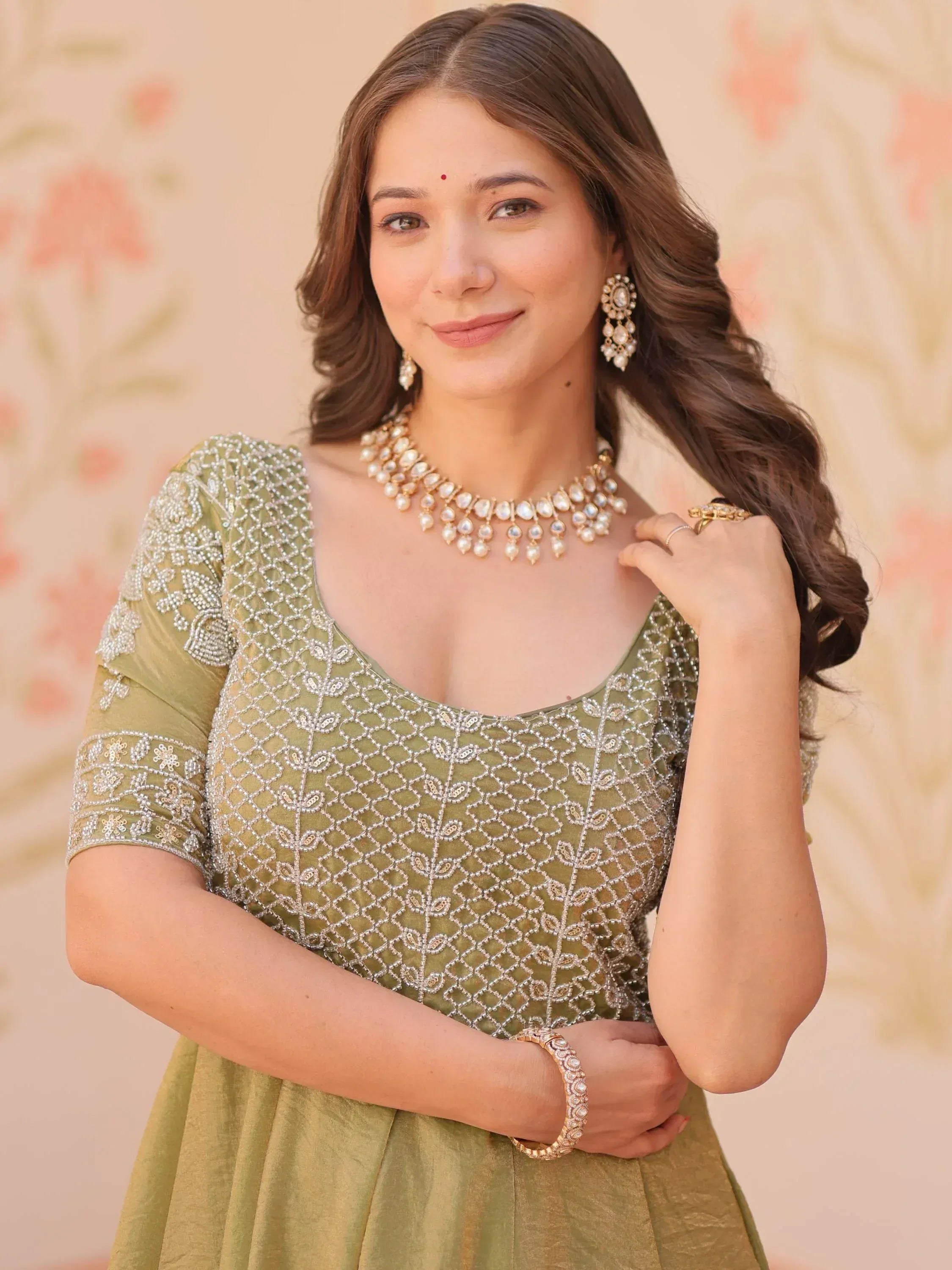 Elegant olive green ethnic gown with intricate embroidery and pearl jewelry