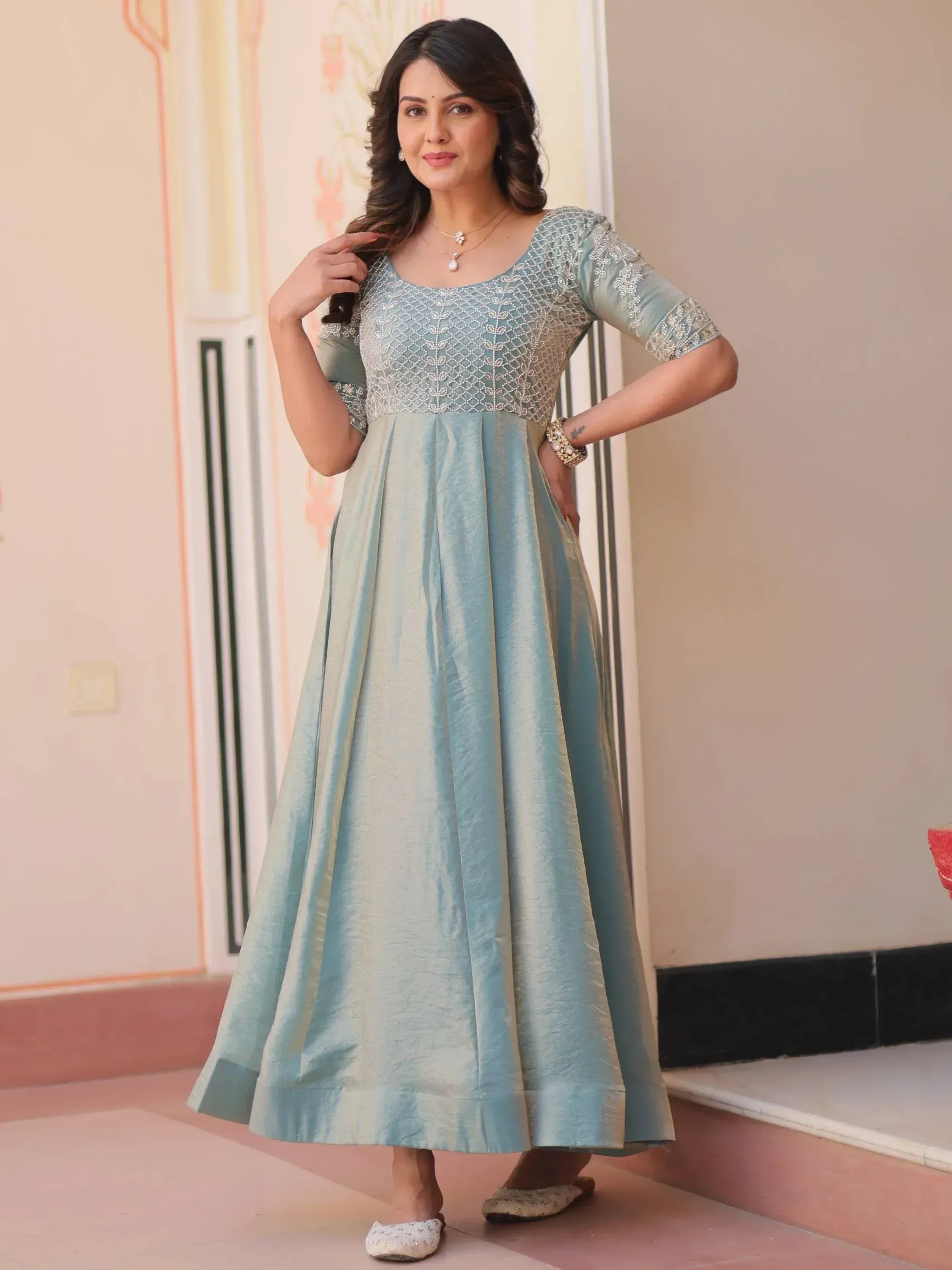Woman in light blue embroidered ethnic gown with flared skirt, perfect for Indian occasions
