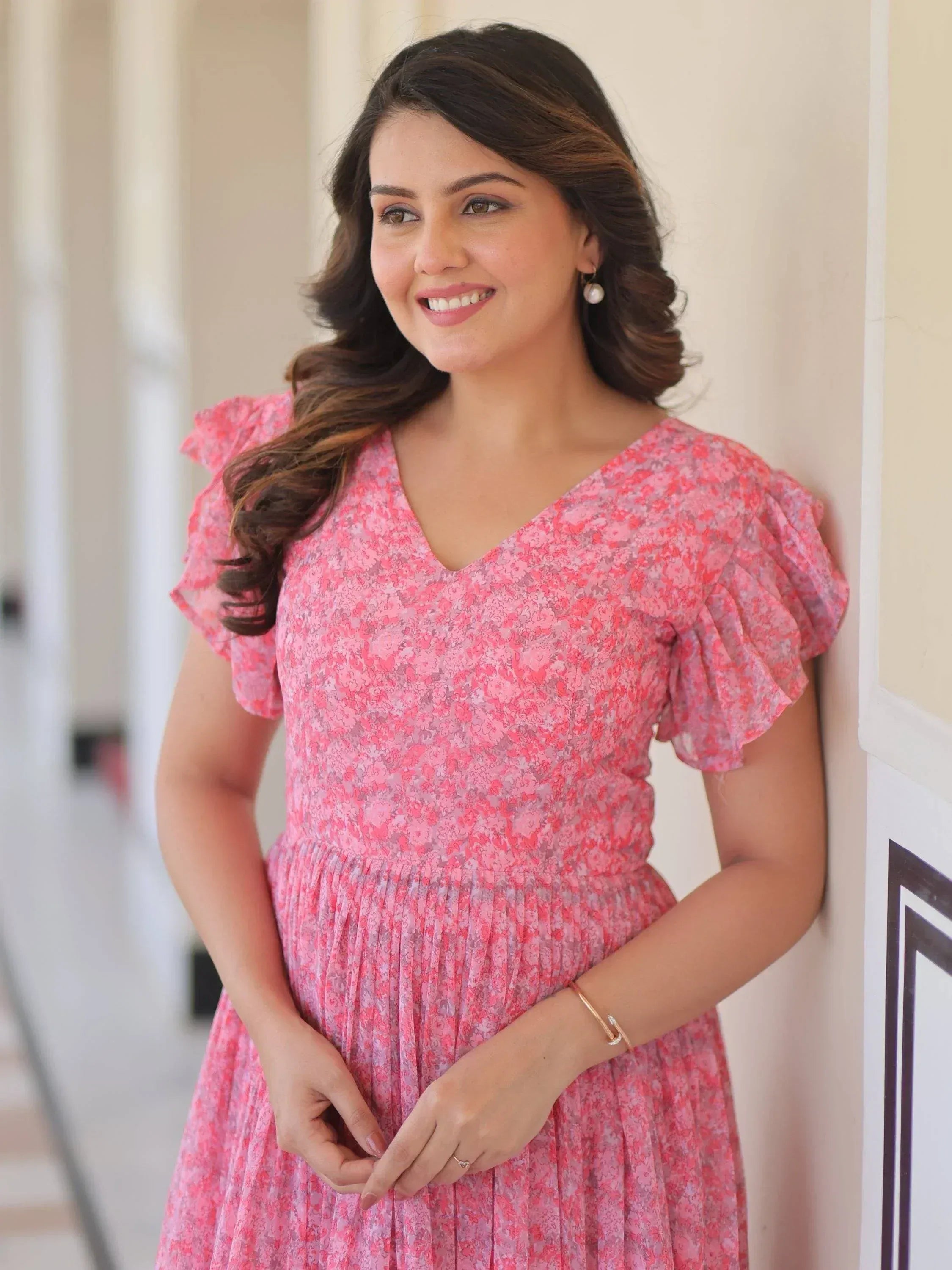 Woman in pink floral ethnic gown with ruffled sleeves, perfect for Indian occasions