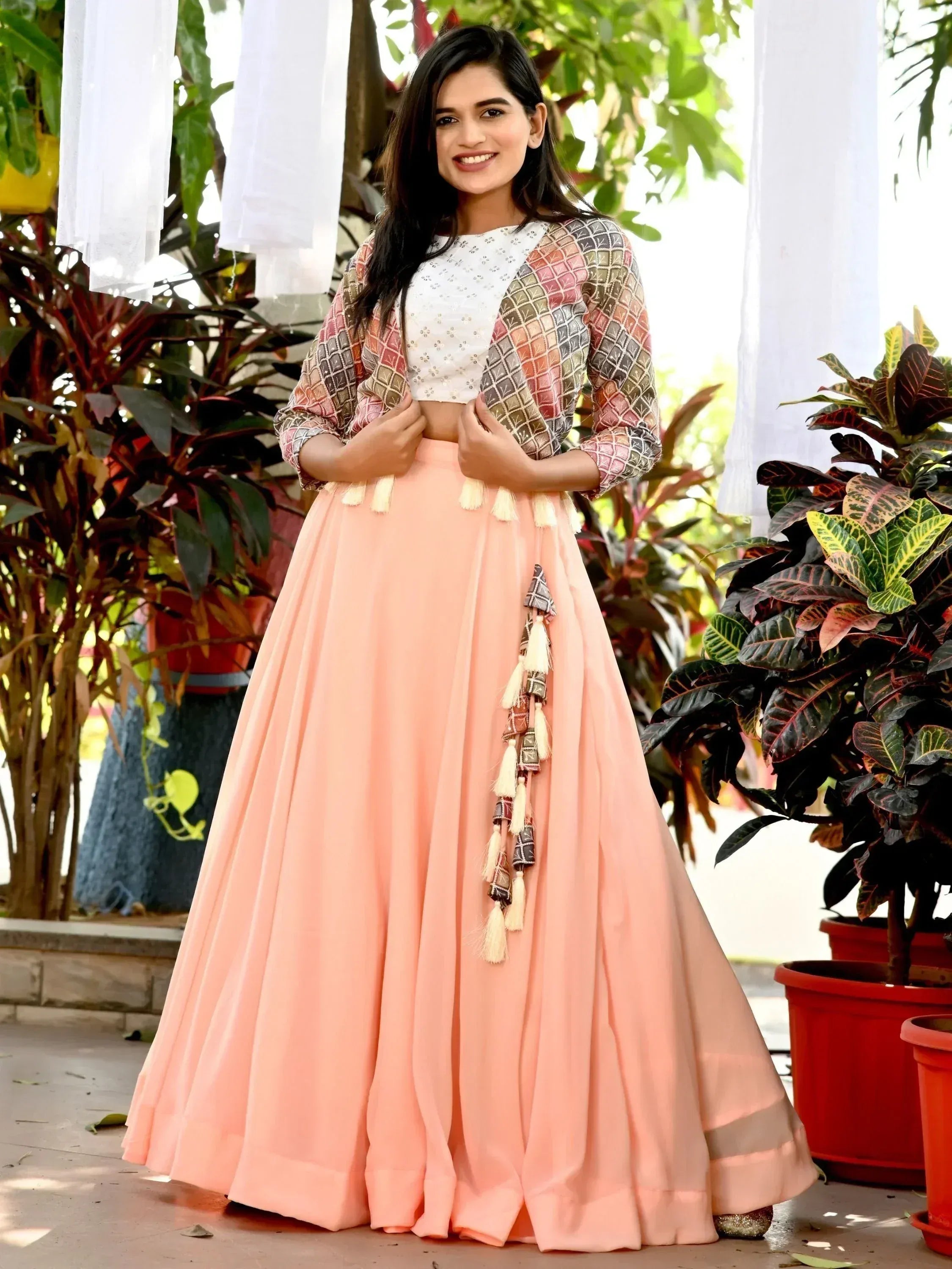 Woman in peach lehenga with printed jacket and tassels, Indian ethnic wear