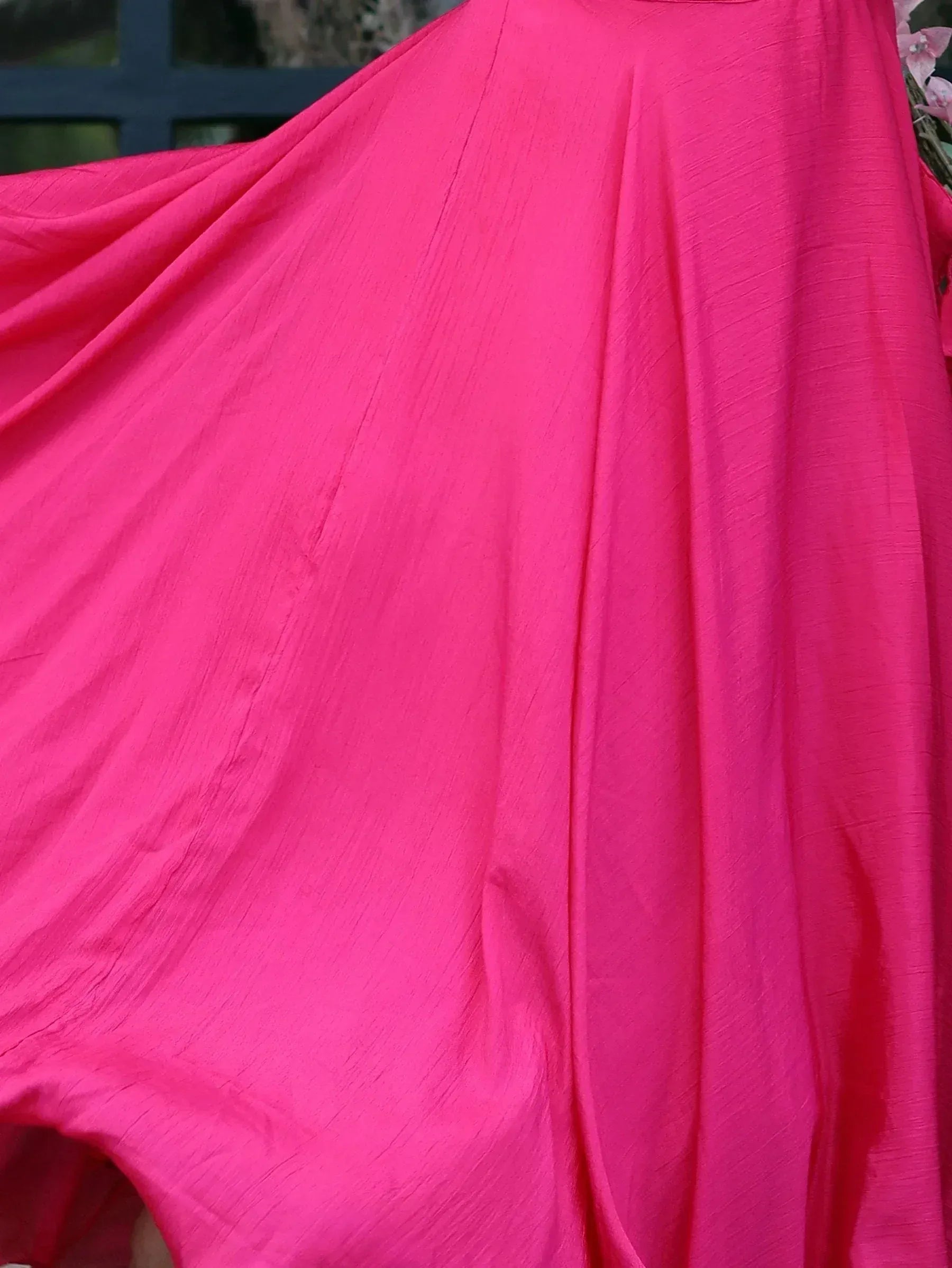 Vibrant pink ethnic gown with flowing fabric, perfect for Indian festive wear