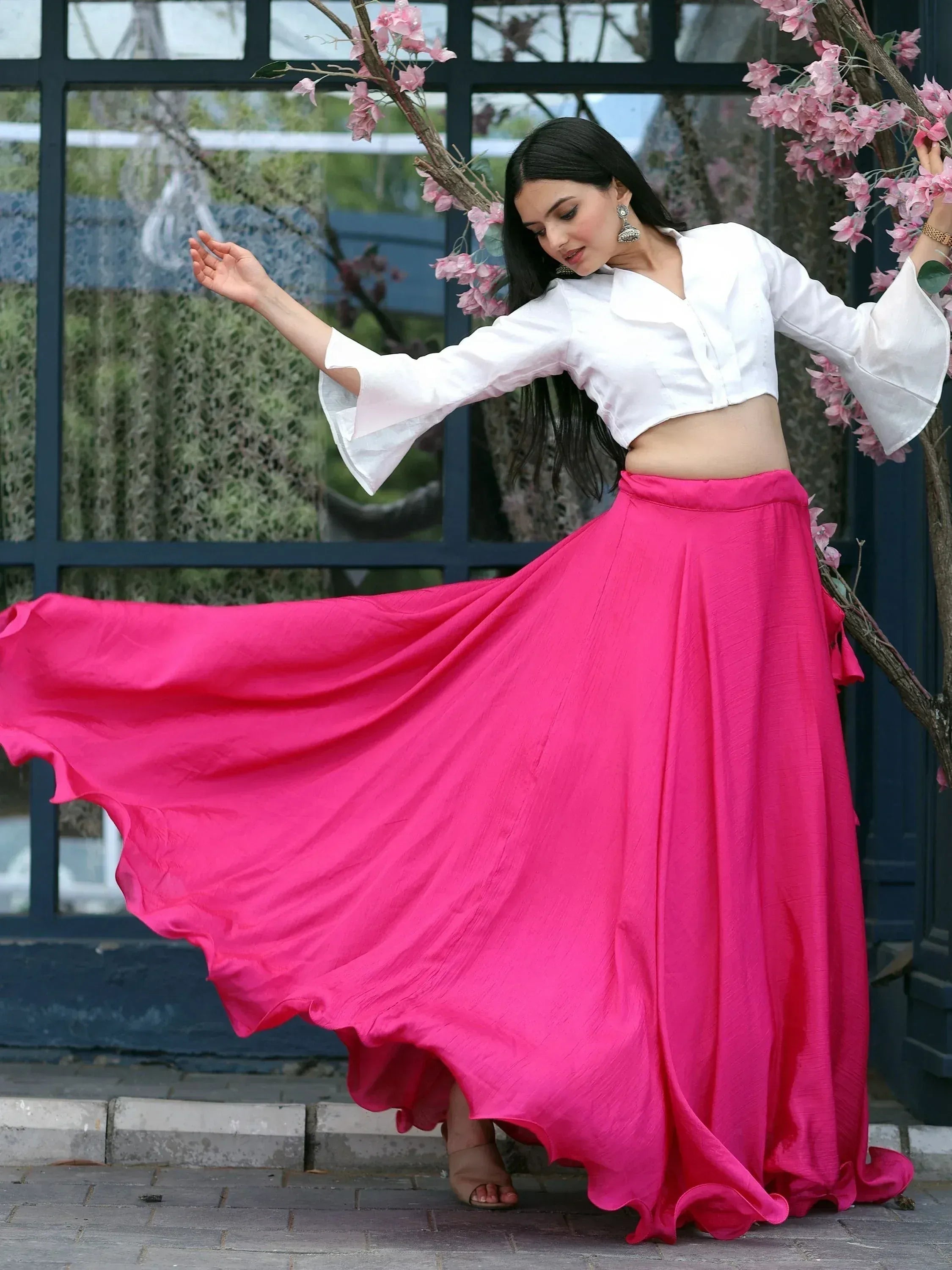 Woman in white crop top and pink flared skirt, ethnic wear for festive occasions