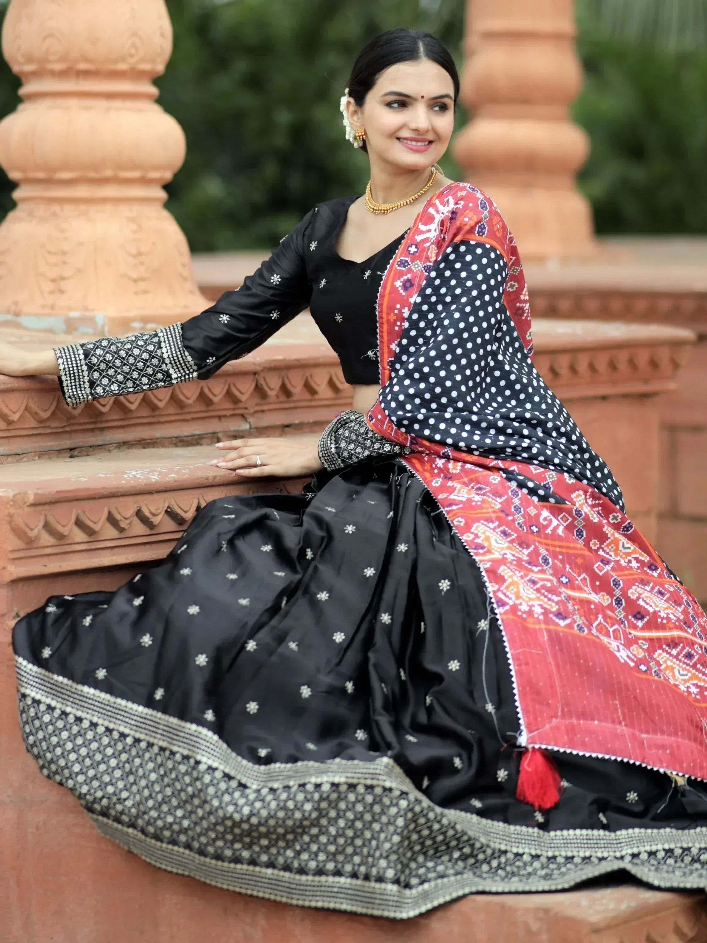 Woman in black embroidered lehenga choli with red and white patterned dupatta, traditional Indian ethnic wear