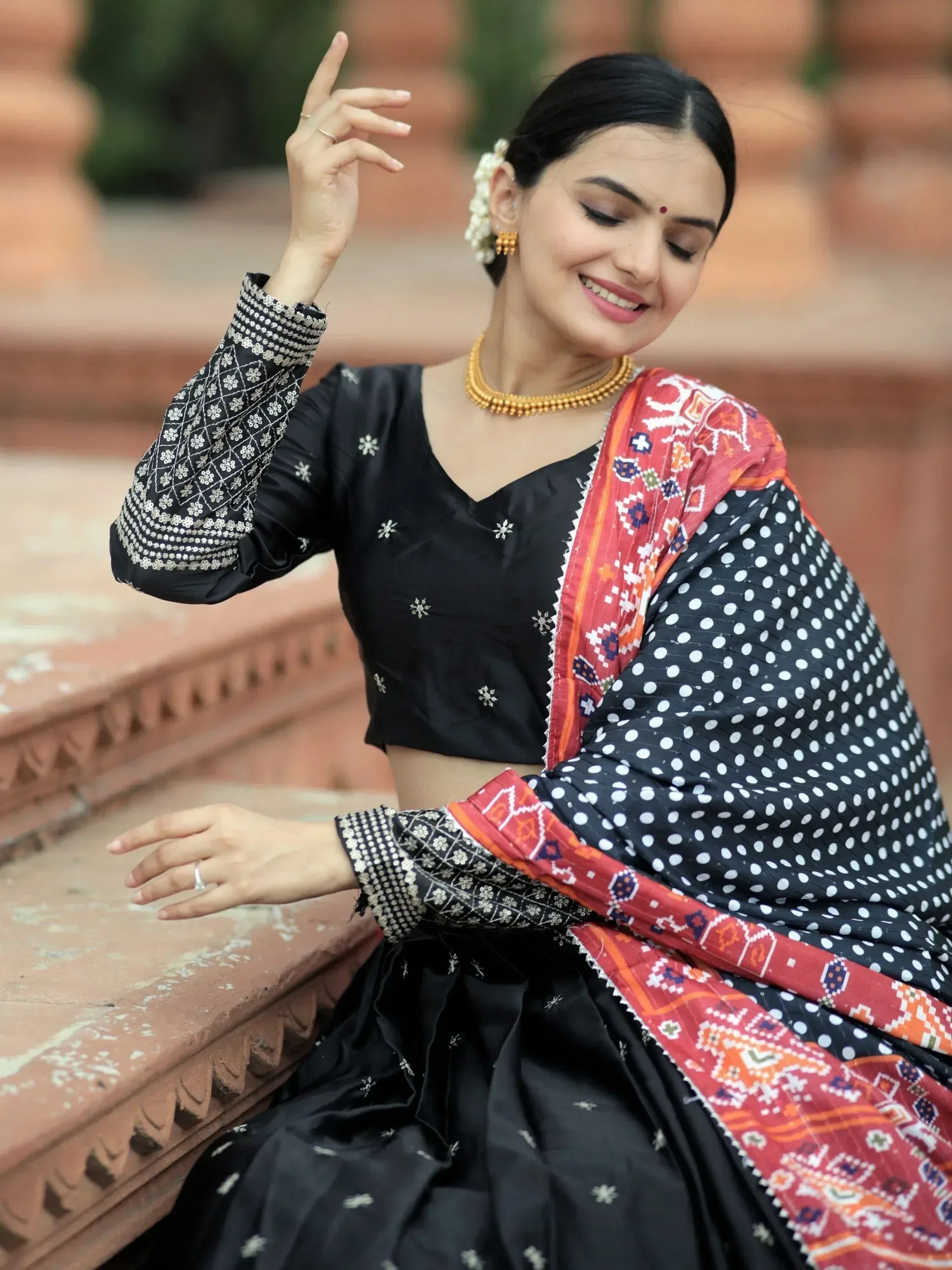 Woman in black embroidered lehenga choli with polka dot dupatta, traditional Indian ethnic wear