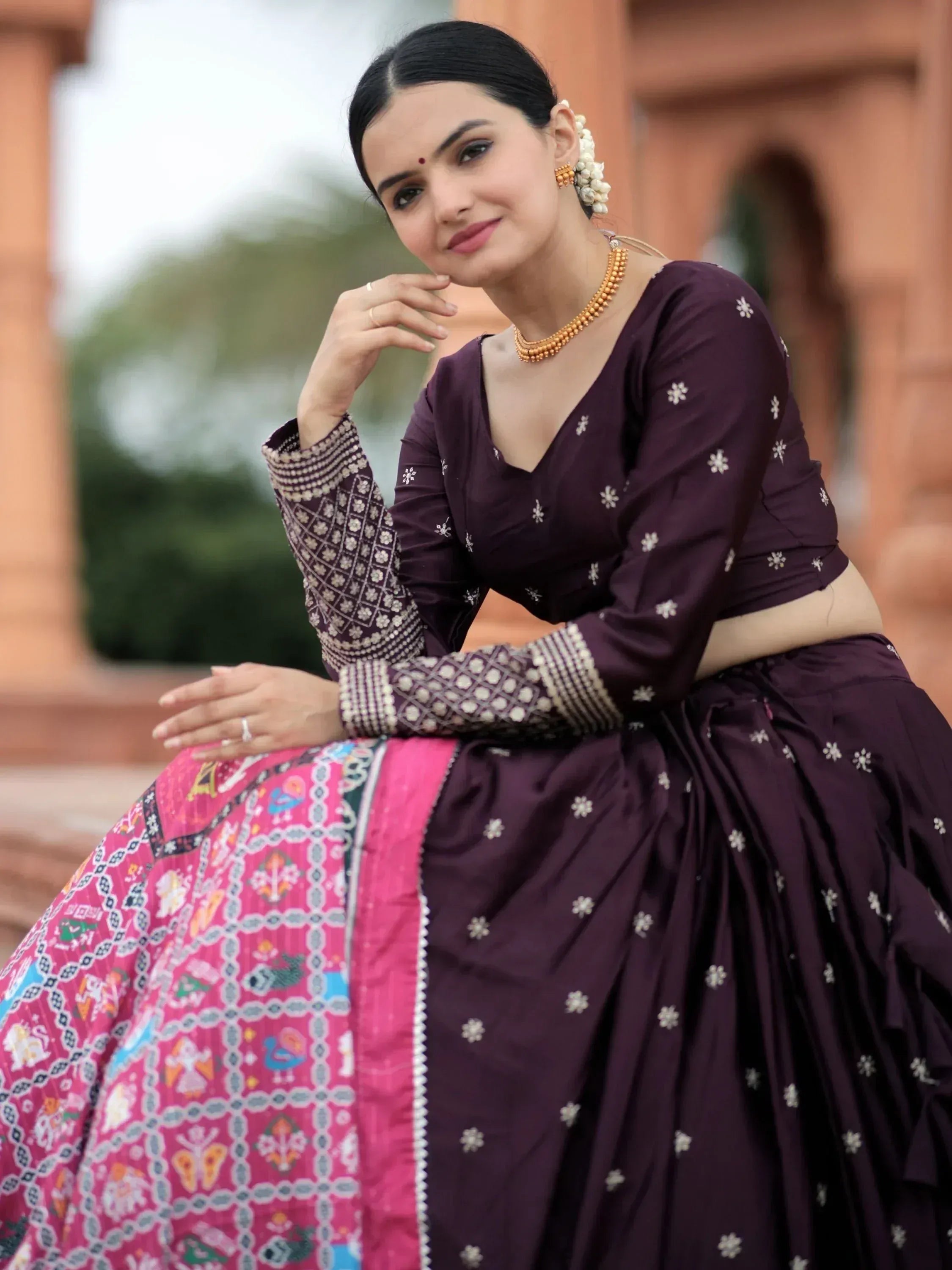 Woman in purple embroidered lehenga choli with pink dupatta, traditional Indian ethnic wear