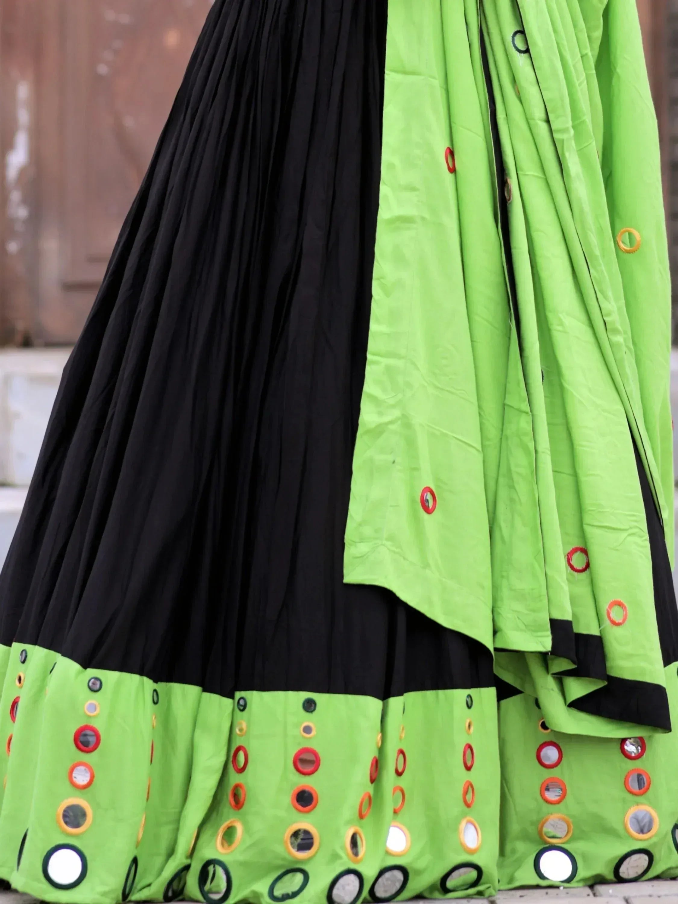 Black and neon green pleated lehenga with mirror work and colorful embroidery, perfect for Indian ethnic wear.