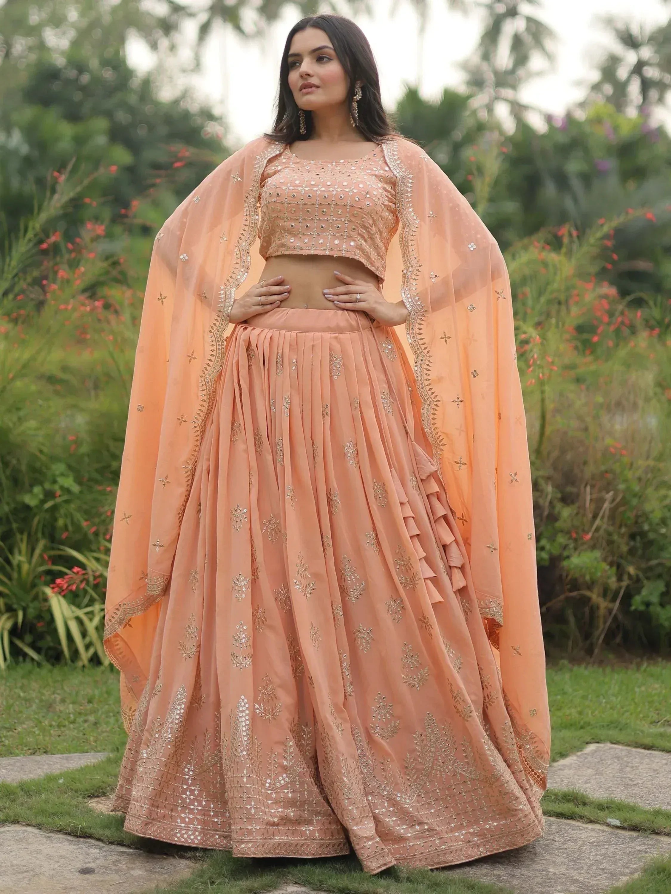 Peach designer lehenga choli with mirror work and ruffled skirt, perfect for Indian weddings and festive occasions