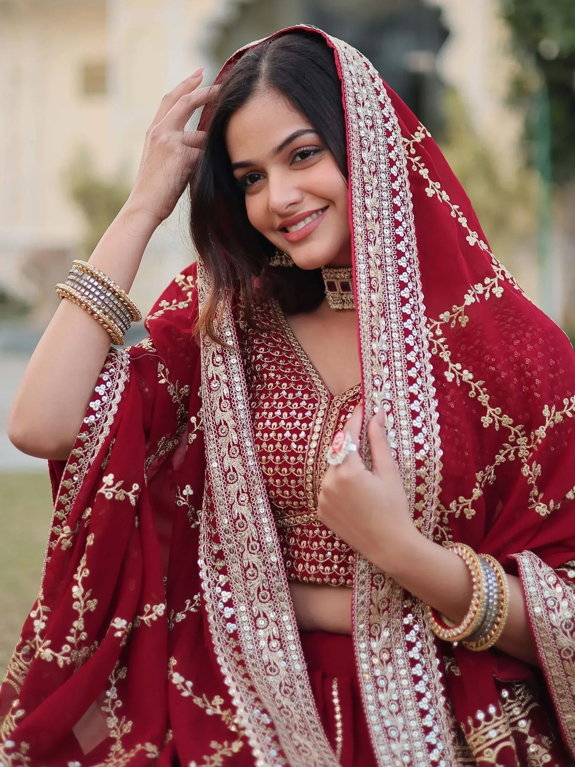 Red embroidered Indian lehenga choli with gold detailing and matching dupatta, perfect for weddings and festive occasions.