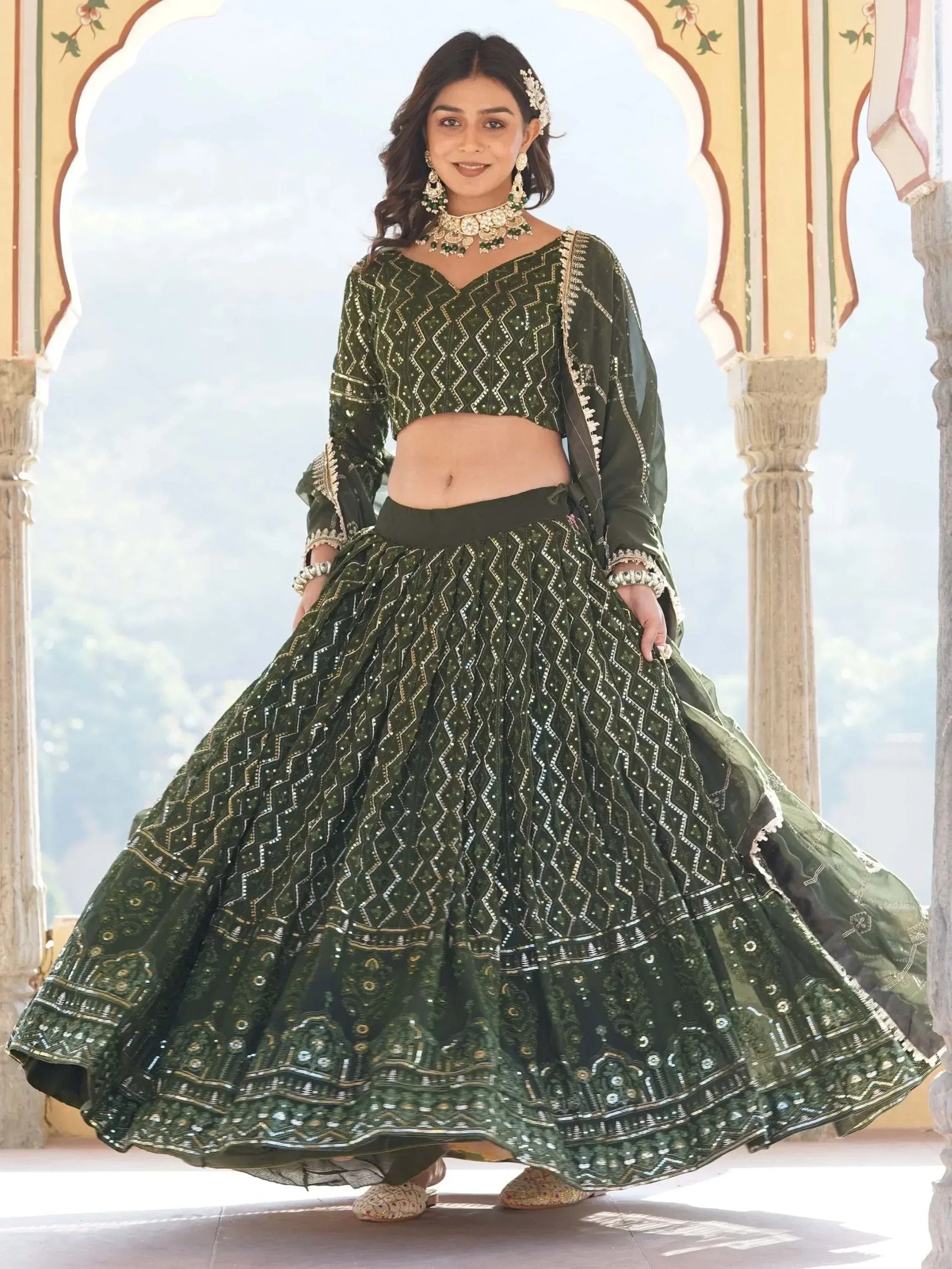 Emerald green designer lehenga choli with intricate gold embroidery, perfect for Indian weddings and festive occasions.