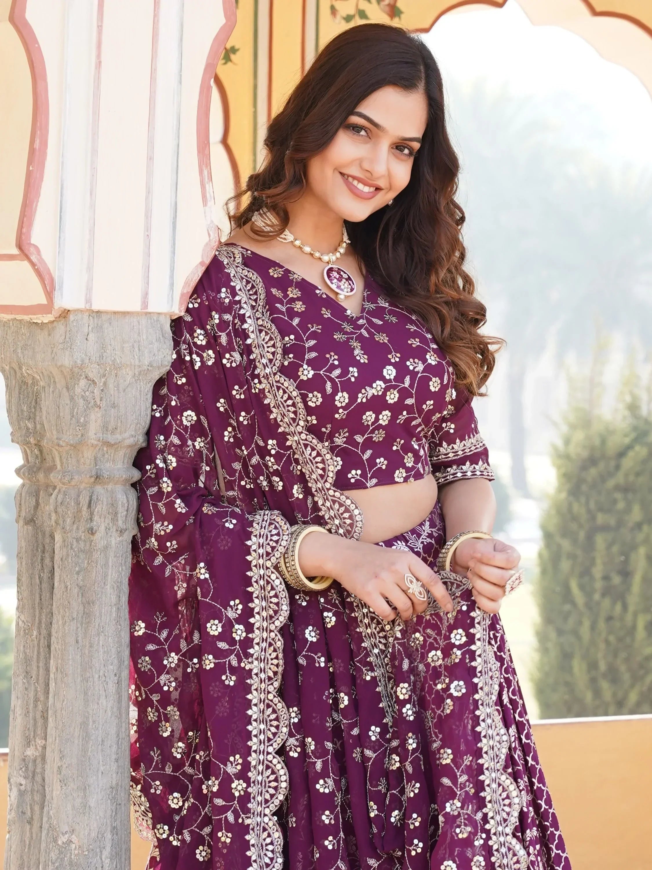 Woman in purple embroidered lehenga choli with floral sequin design, traditional Indian ethnic wear