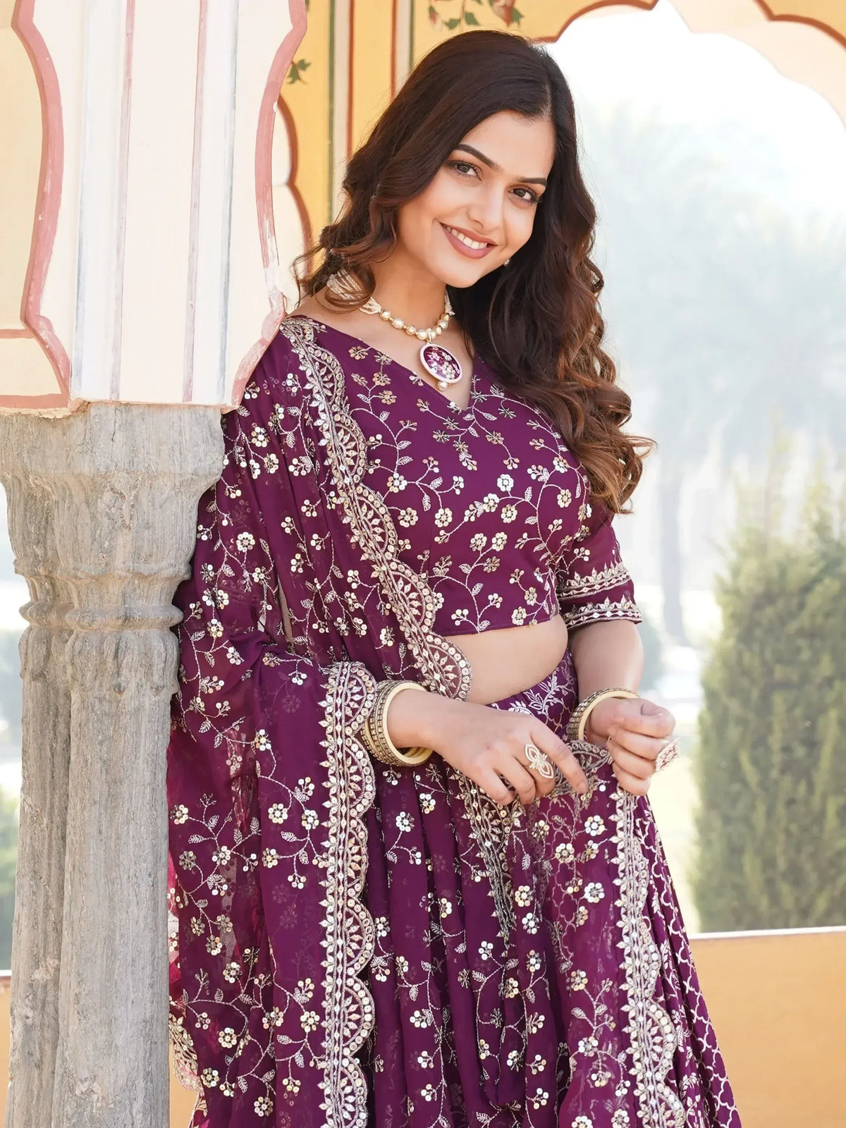 Woman in purple embroidered lehenga choli with floral sequin design, traditional Indian ethnic wear