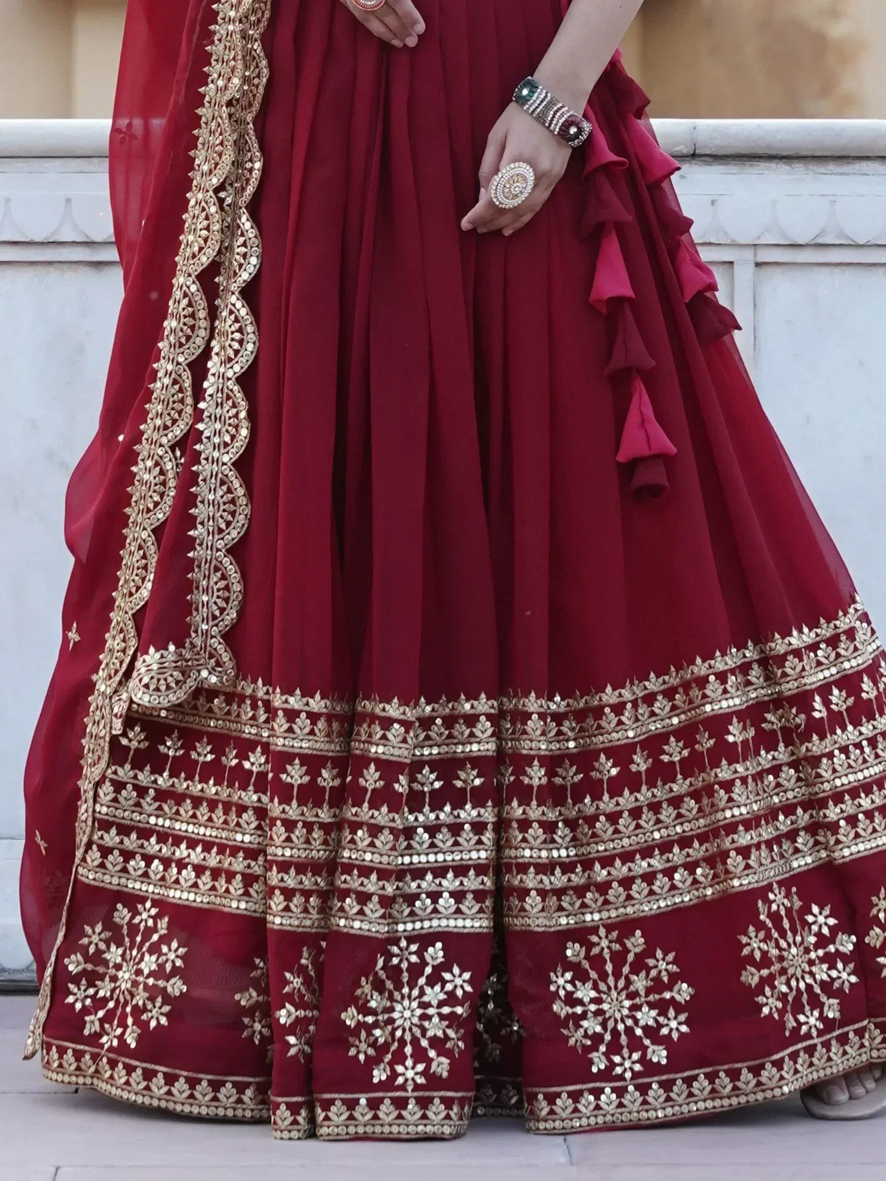 Maroon lehenga choli with gold embroidery and ruffle details, perfect for Indian ethnic wear occasions