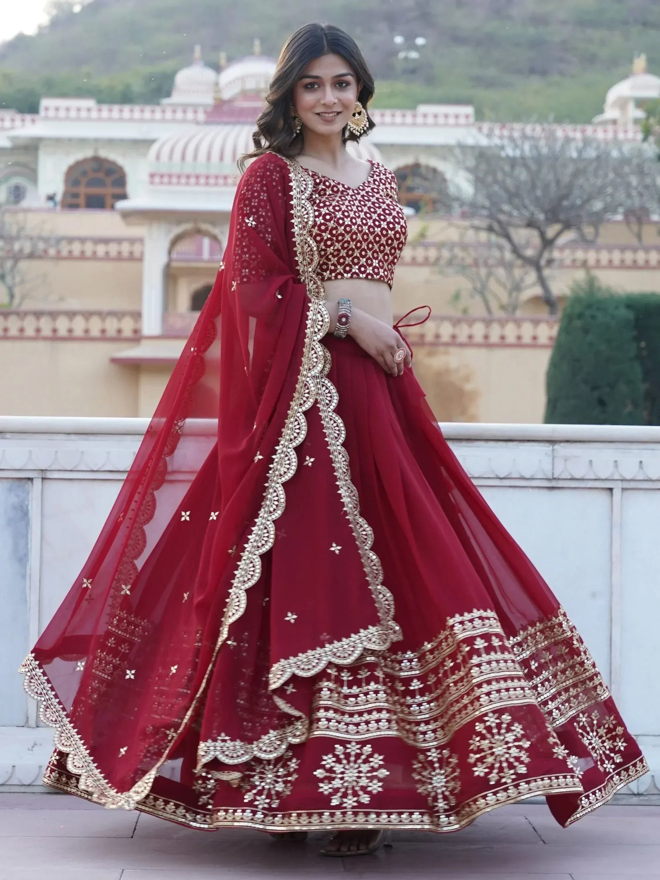 Maroon designer lehenga choli with gold embroidery, perfect for Indian weddings and festive occasions.