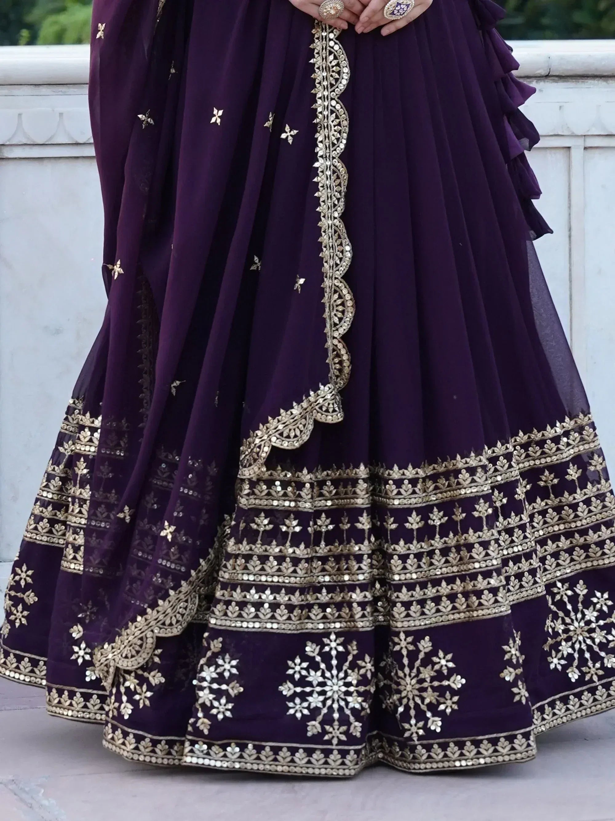 Purple designer lehenga with gold embroidery and mirror work, perfect for Indian ethnic wear occasions.