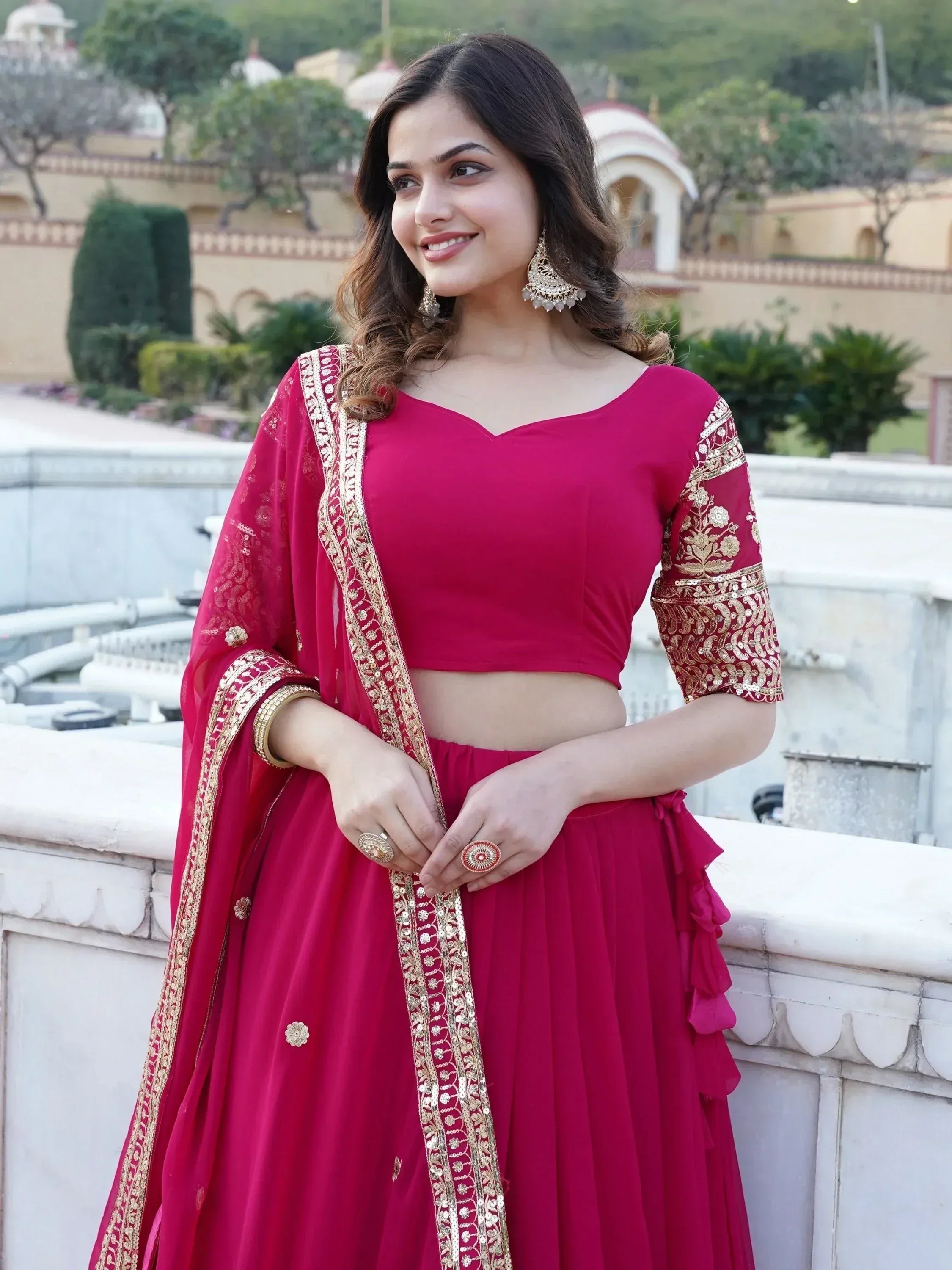 Woman in red designer lehenga choli with gold embroidery, perfect for Indian ethnic wear occasions