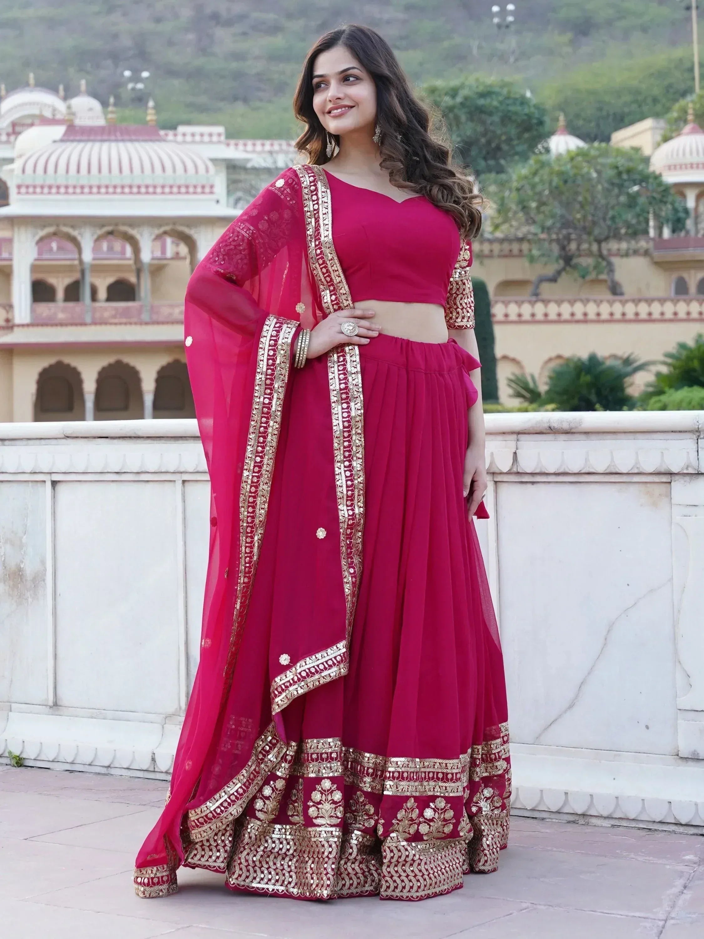 Woman in maroon designer lehenga choli with gold embroidery, perfect for Indian ethnic wear occasions