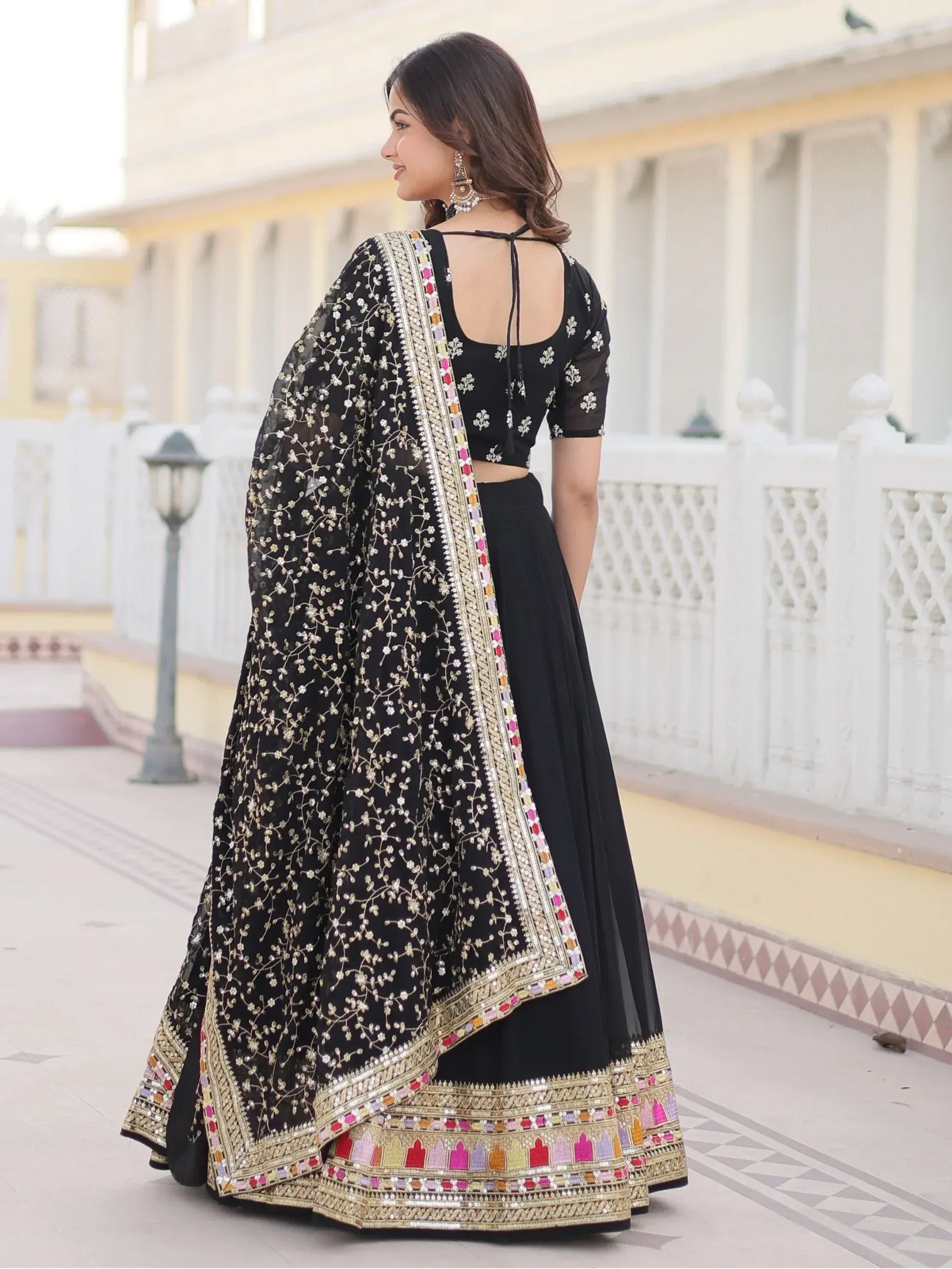Black embroidered lehenga choli with floral motifs and colorful border, perfect for Indian ethnic wear