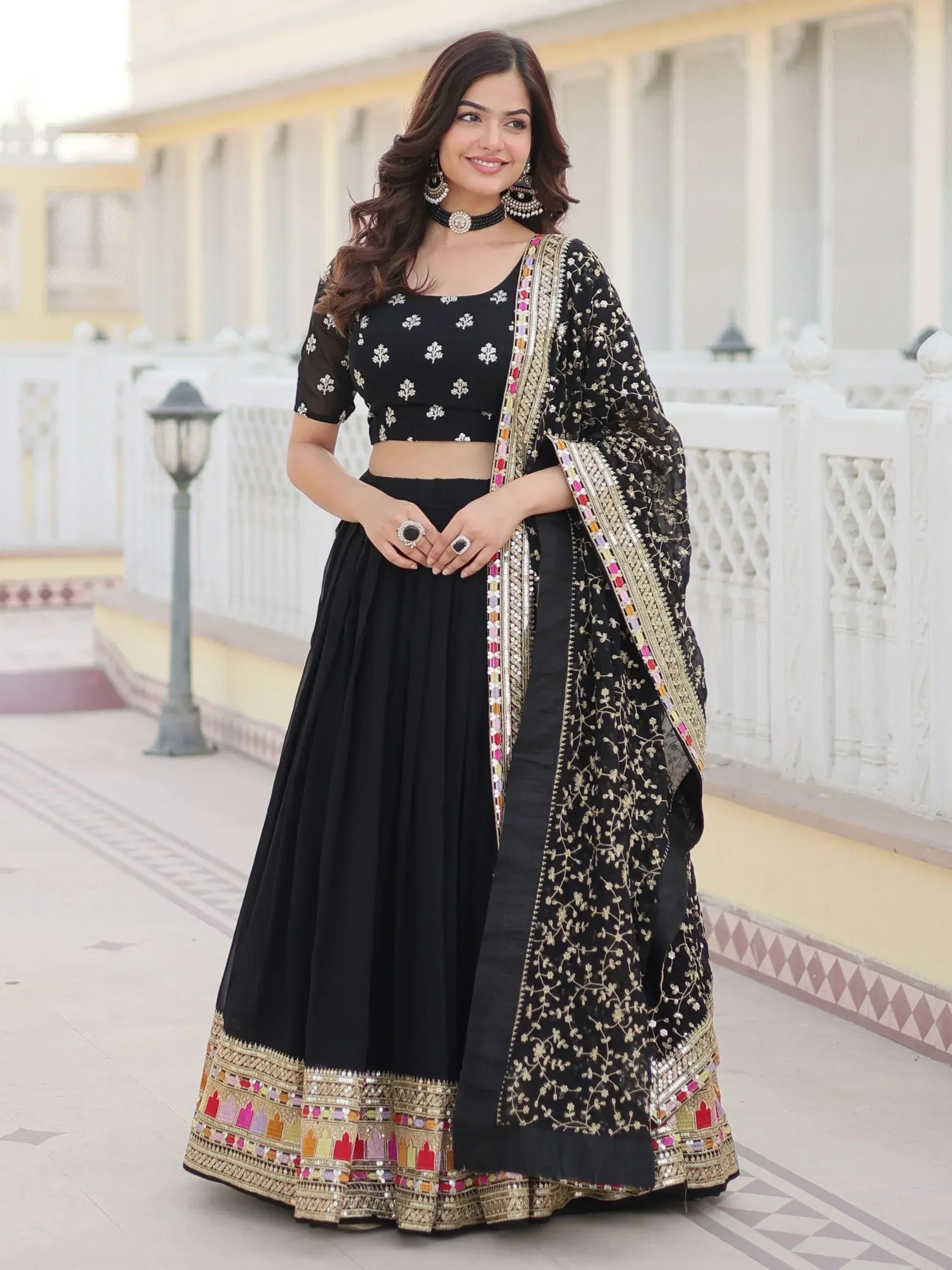 Black embroidered lehenga choli with gold and colorful mirror work, perfect for Indian ethnic wear occasions.