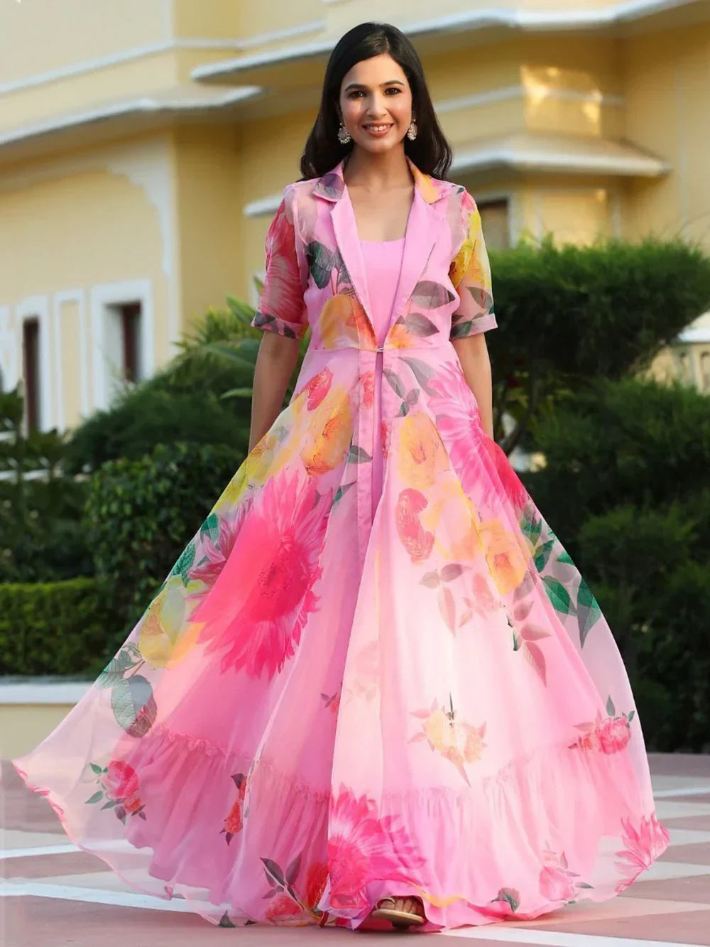 Woman in a pink floral printed ethnic gown with flared silhouette, outdoor setting