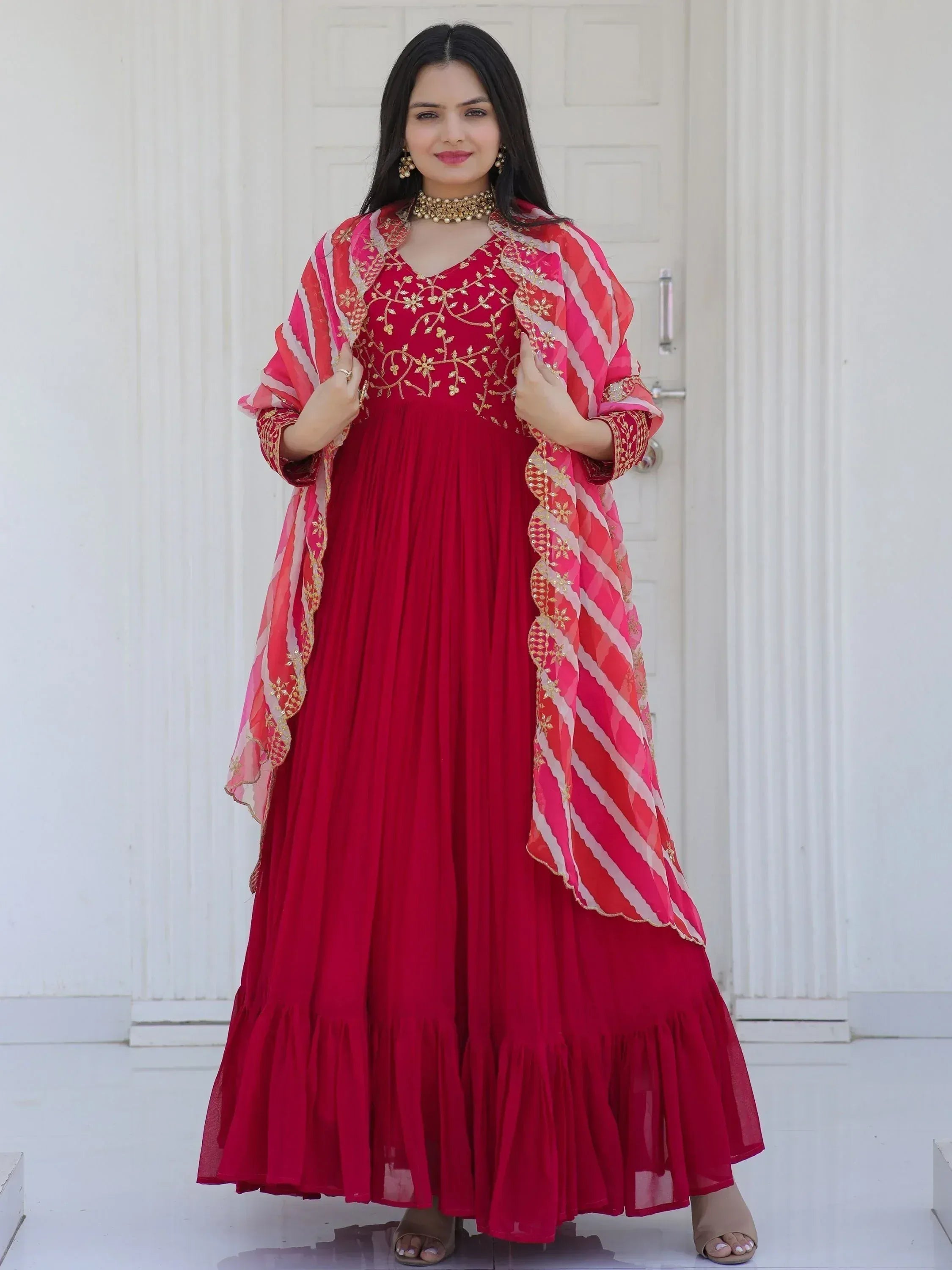 Red ethnic gown with gold embroidery and striped dupatta, perfect for Indian occasions