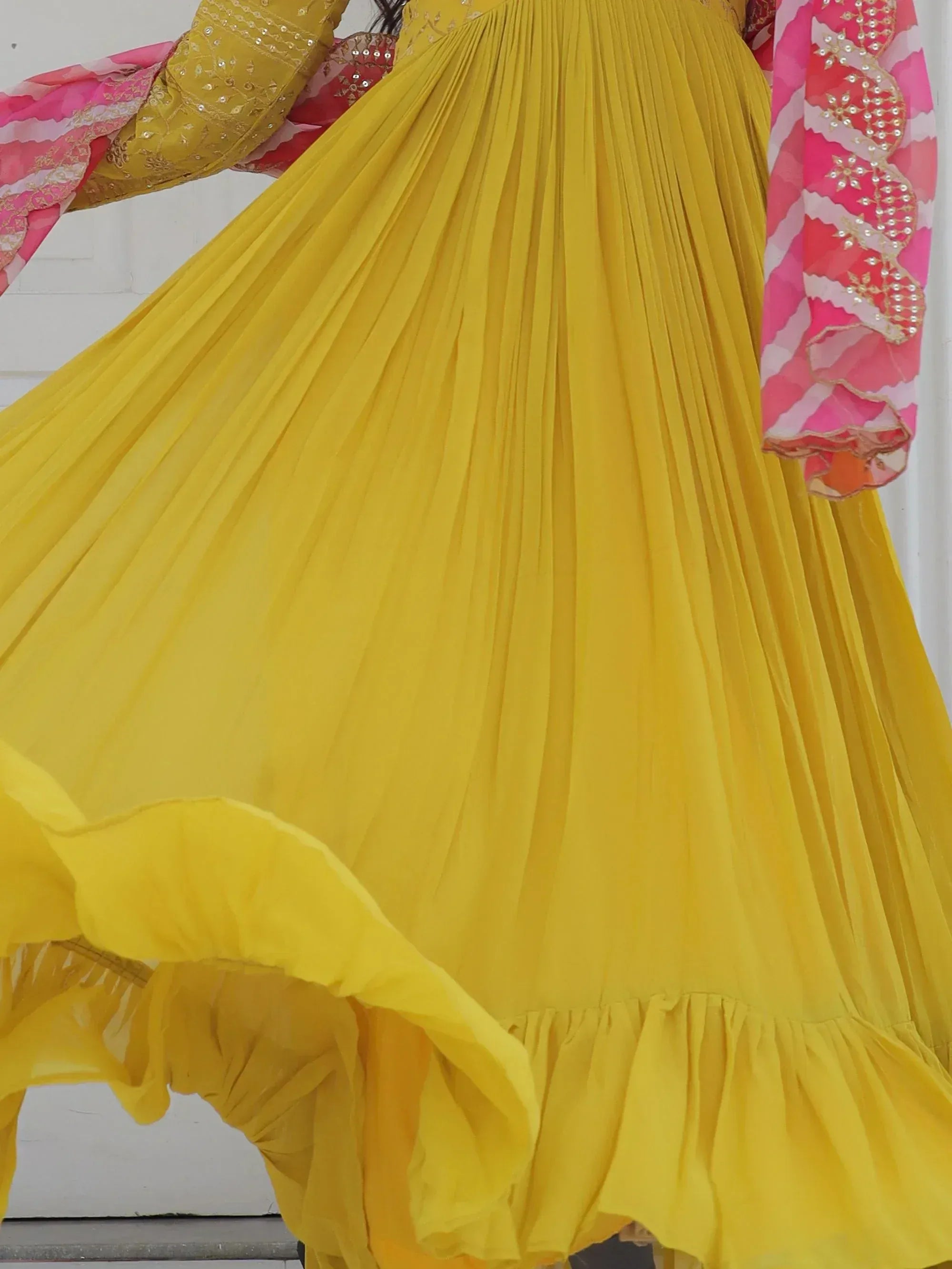 Yellow pleated lehenga choli with pink dupatta, ethnic Indian wear for festive occasions