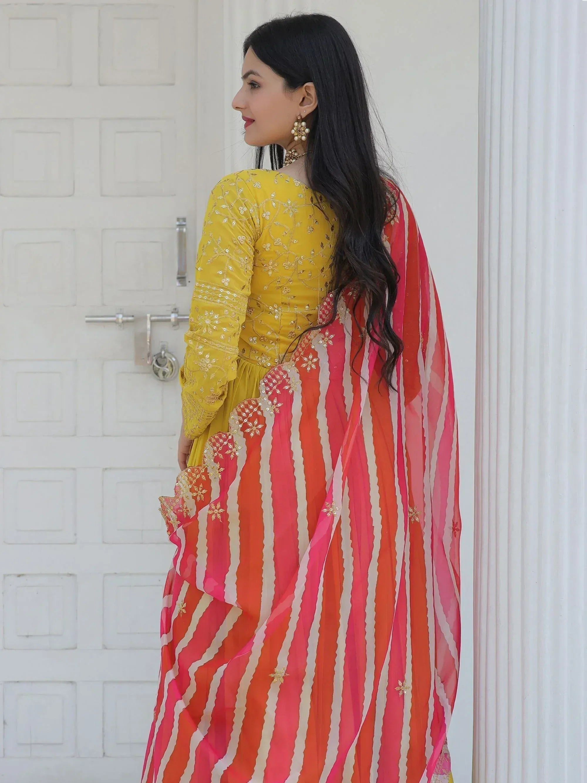Woman in yellow embroidered kurta with pink-orange striped dupatta, Indian ethnic wear