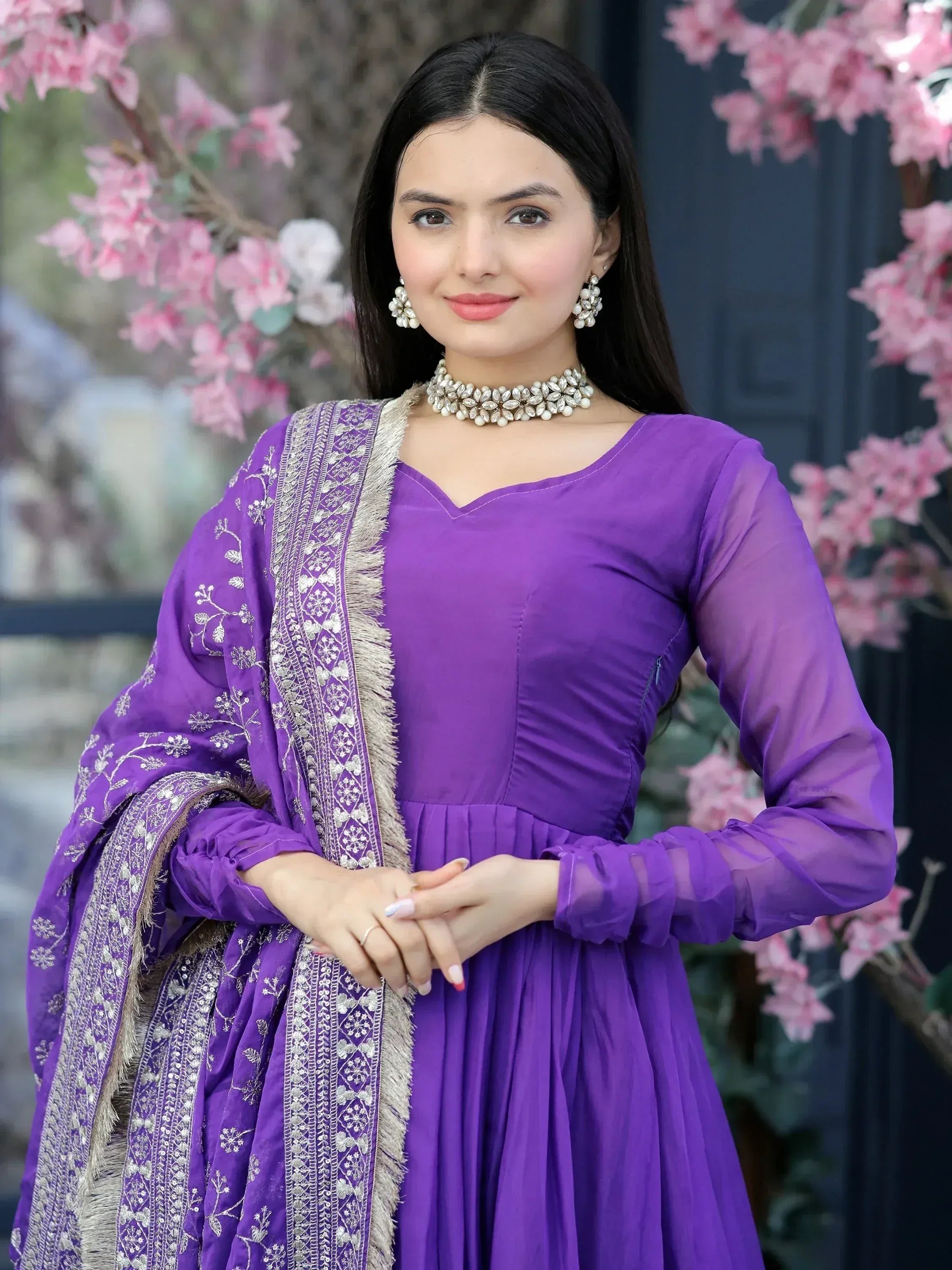 Purple ethnic gown with silver embroidery and matching dupatta, styled with pearl jewelry for festive occasions