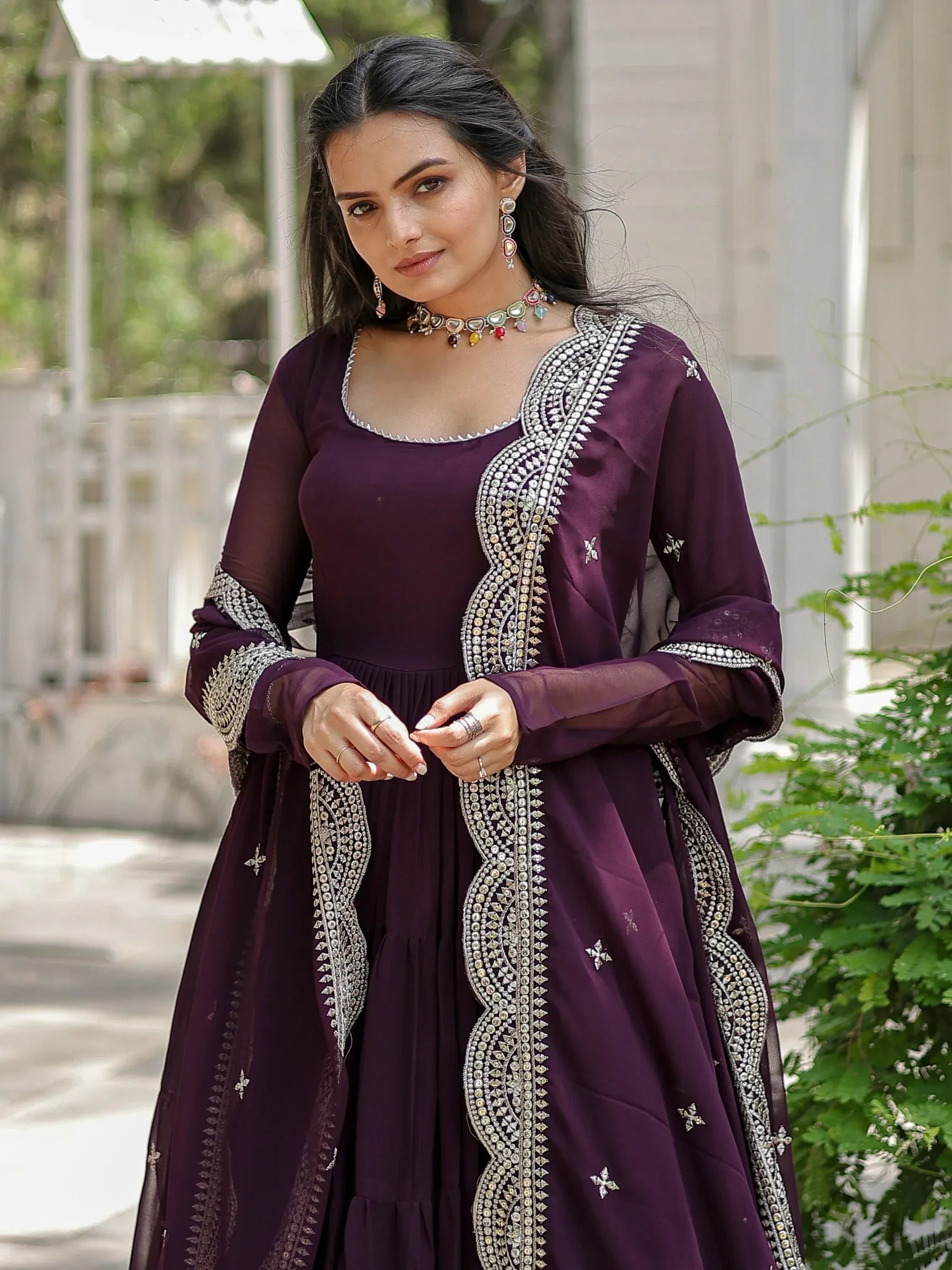 Woman wearing a designer purple ethnic gown with silver embroidery outdoors