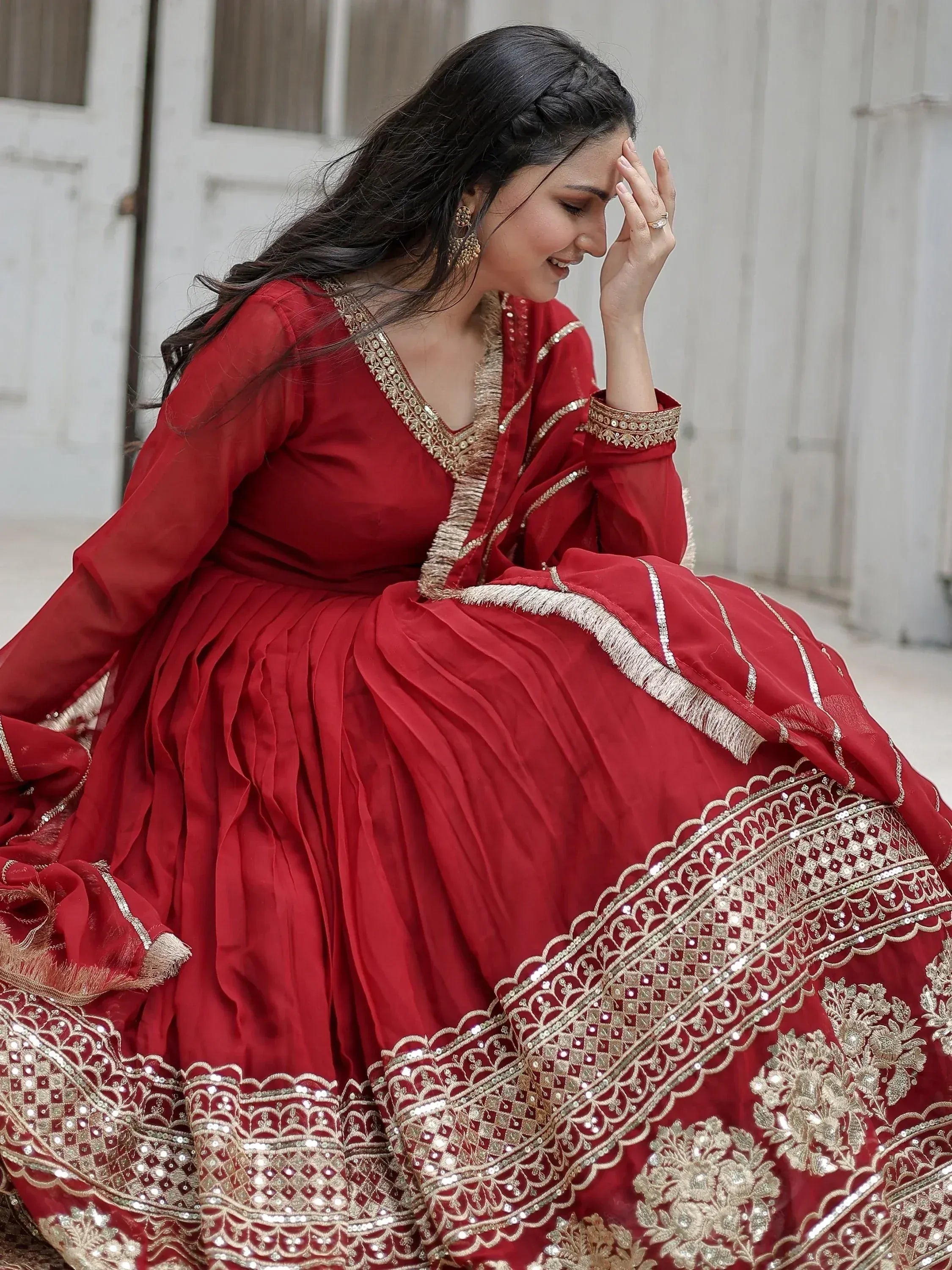 Red ethnic gown with gold embroidery, perfect for Indian weddings and festive occasions.