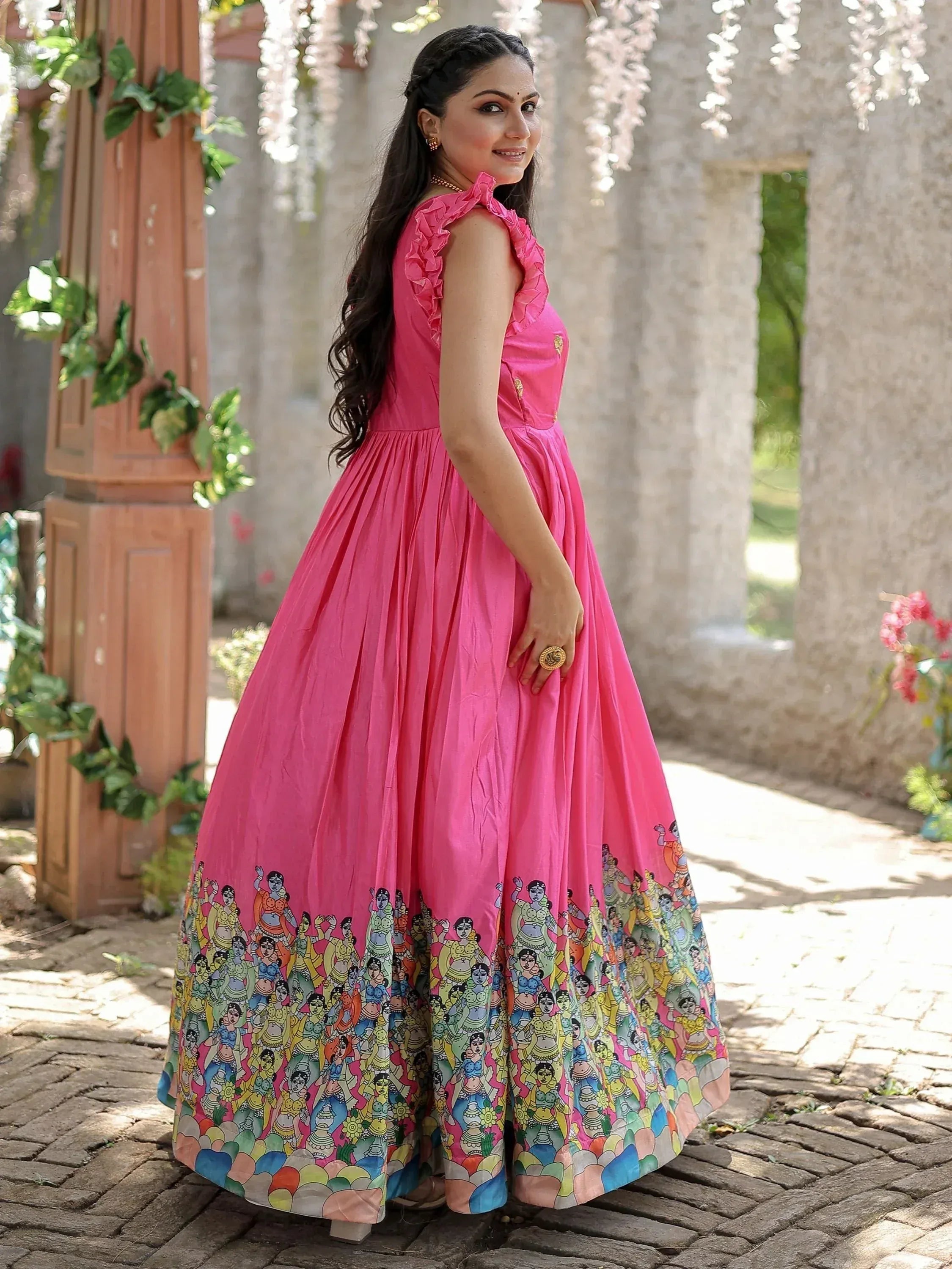Pink ethnic gown with ruffled neckline and colorful folk art print, perfect for Indian occasions