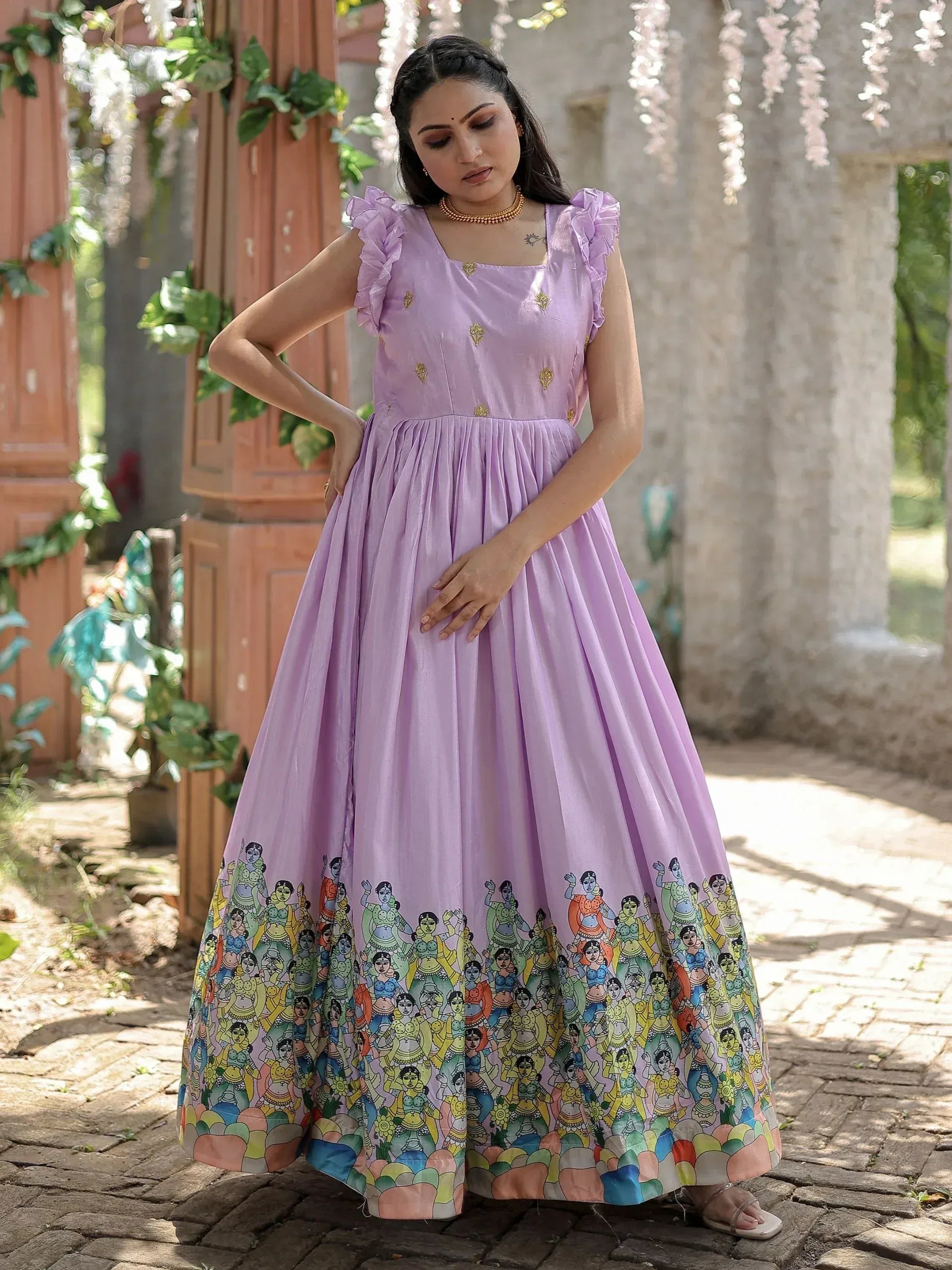 Lavender ethnic gown with ruffle sleeves and colorful folk art print, perfect for Indian occasions.