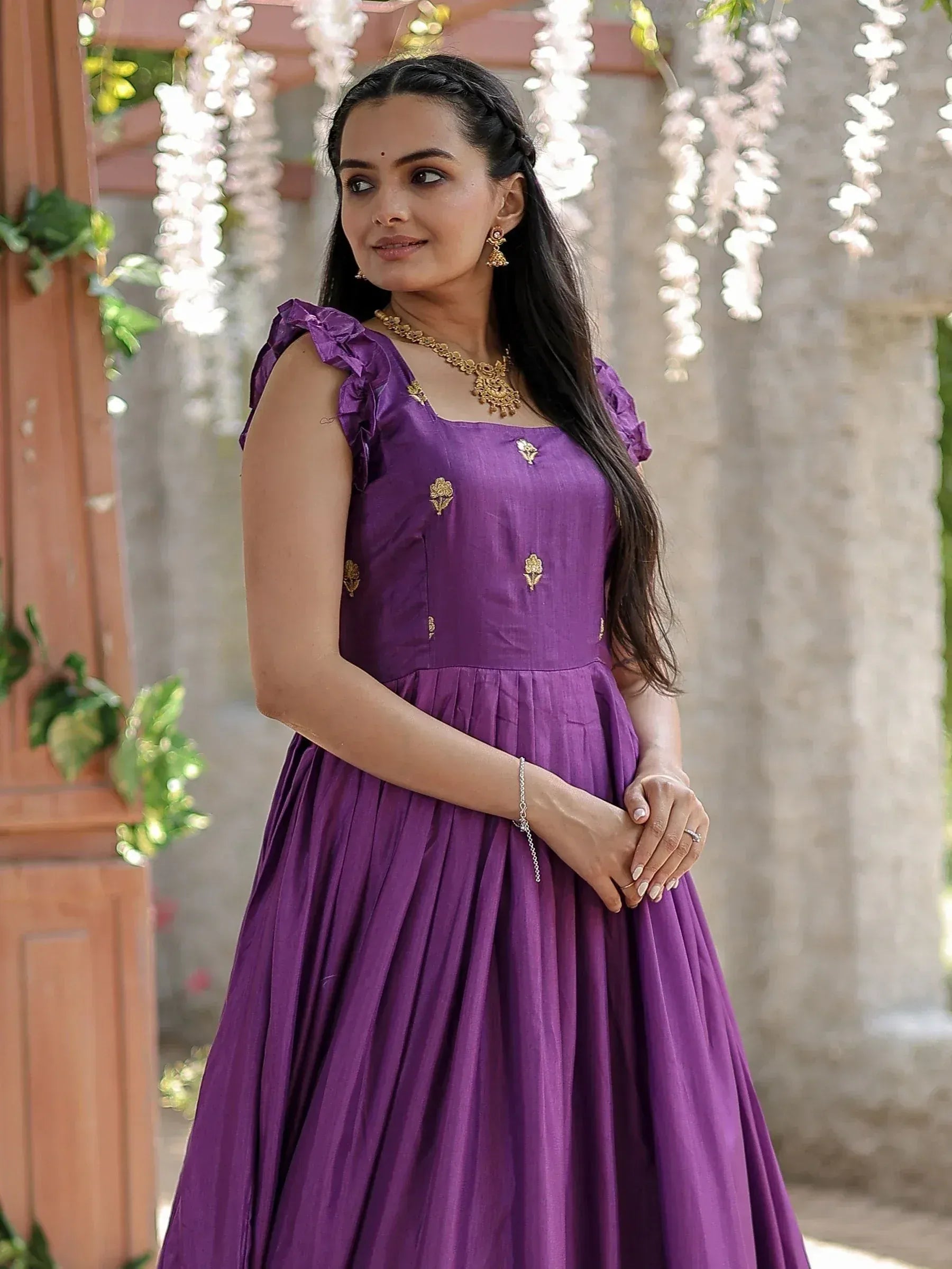Purple ethnic gown with gold embroidery, ruffled sleeves, and pleated skirt for Indian occasions