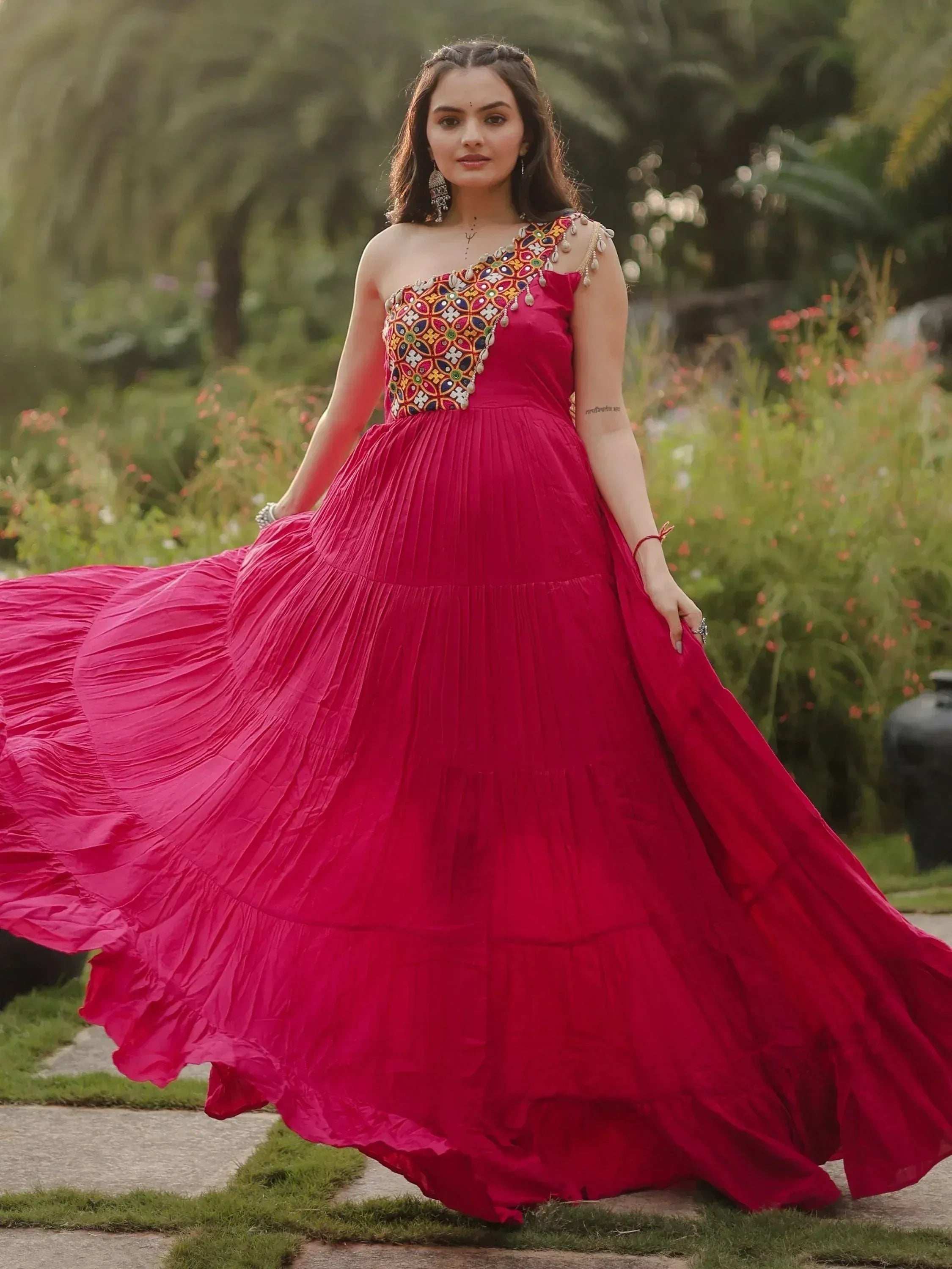 Vibrant pink ethnic gown with colorful mirror work, perfect for Indian weddings and festive occasions.
