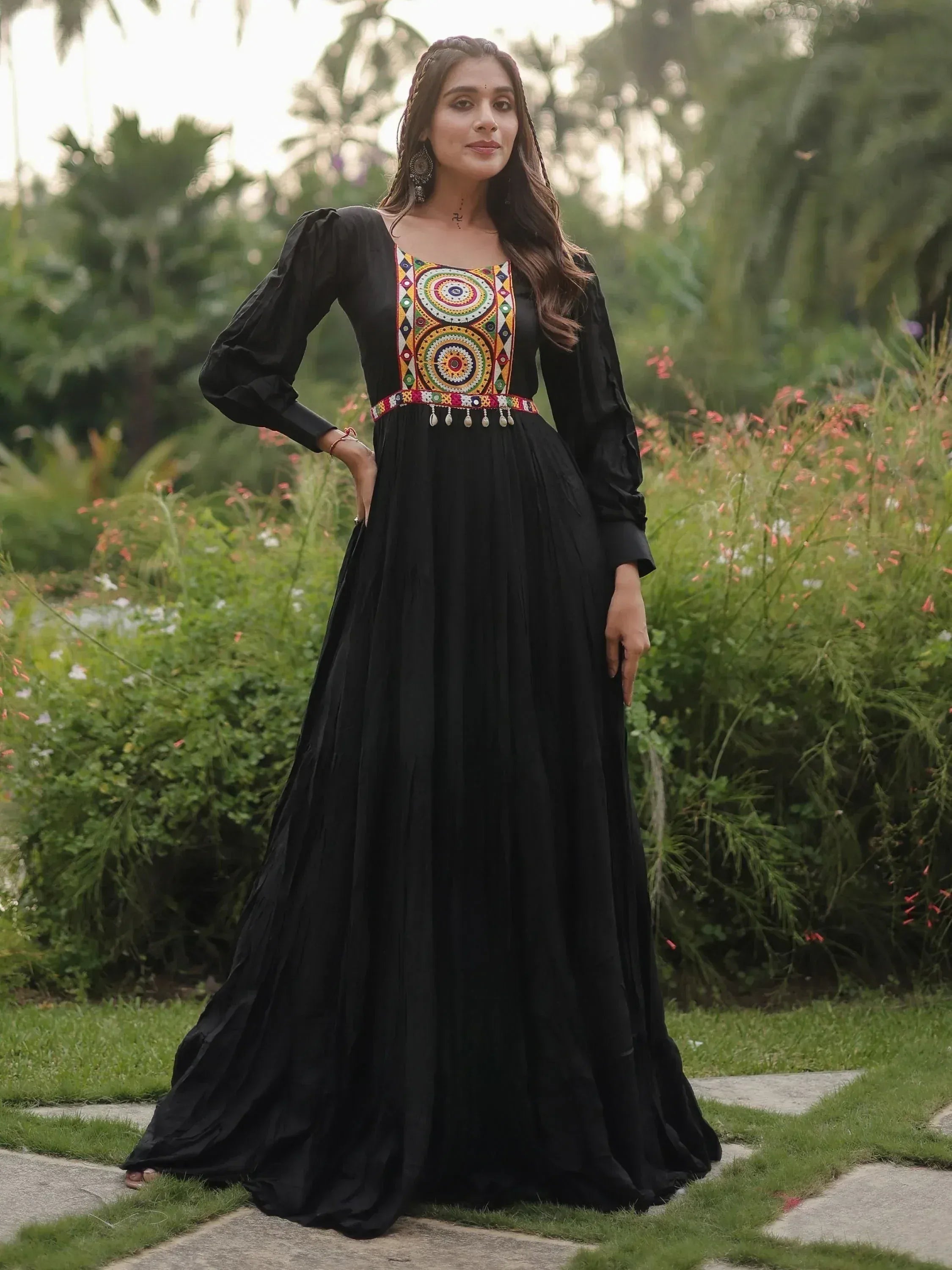 Black ethnic gown with colorful mirror work, long sleeves, and flared skirt, perfect for Indian occasions.
