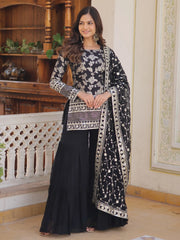 Woman wearing black embroidered Indian ethnic suit with dupatta, standing indoors at Ethnic Plus
