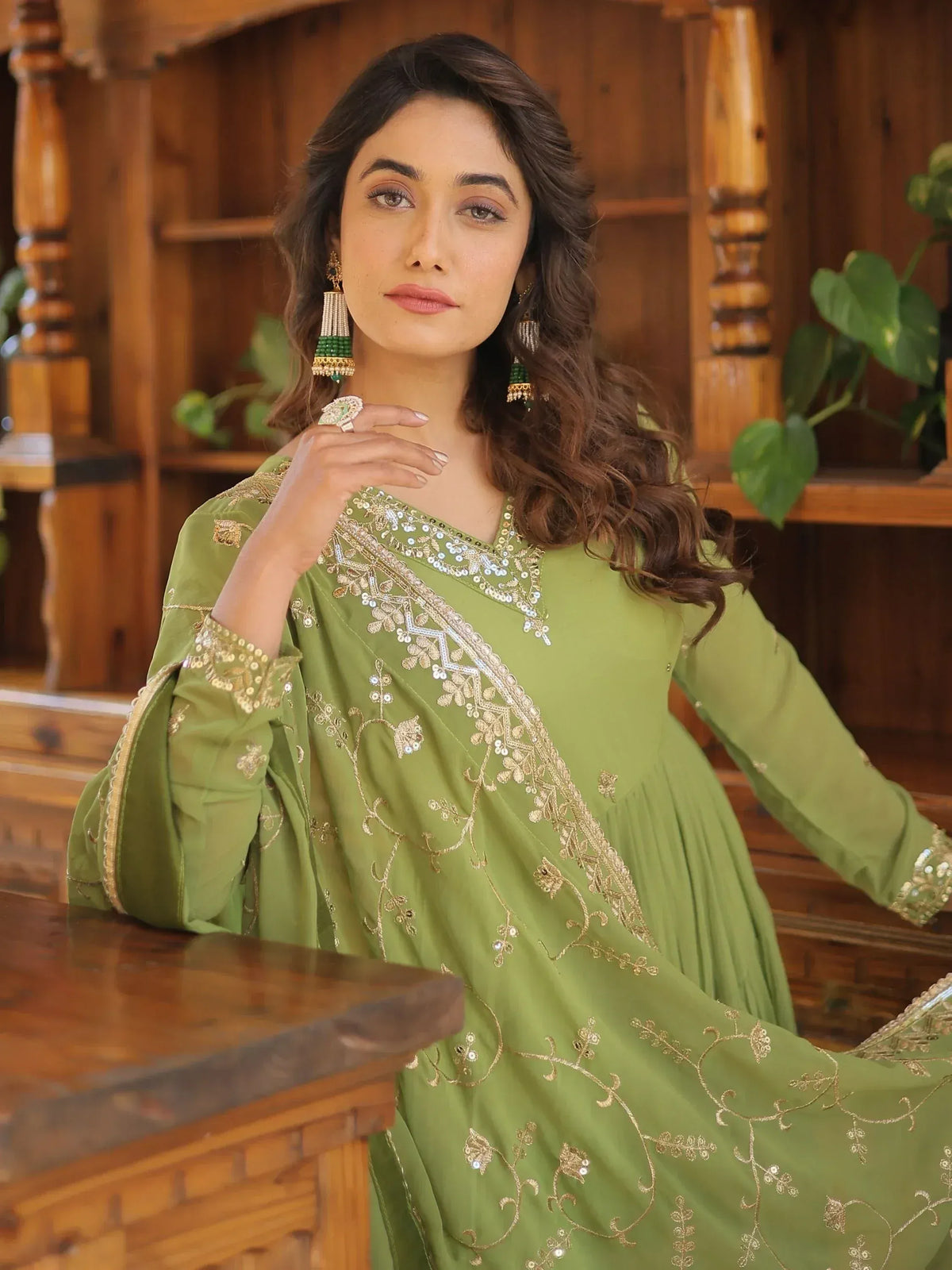 Green embroidered ethnic gown with gold detailing, perfect for Indian festive occasions and weddings.