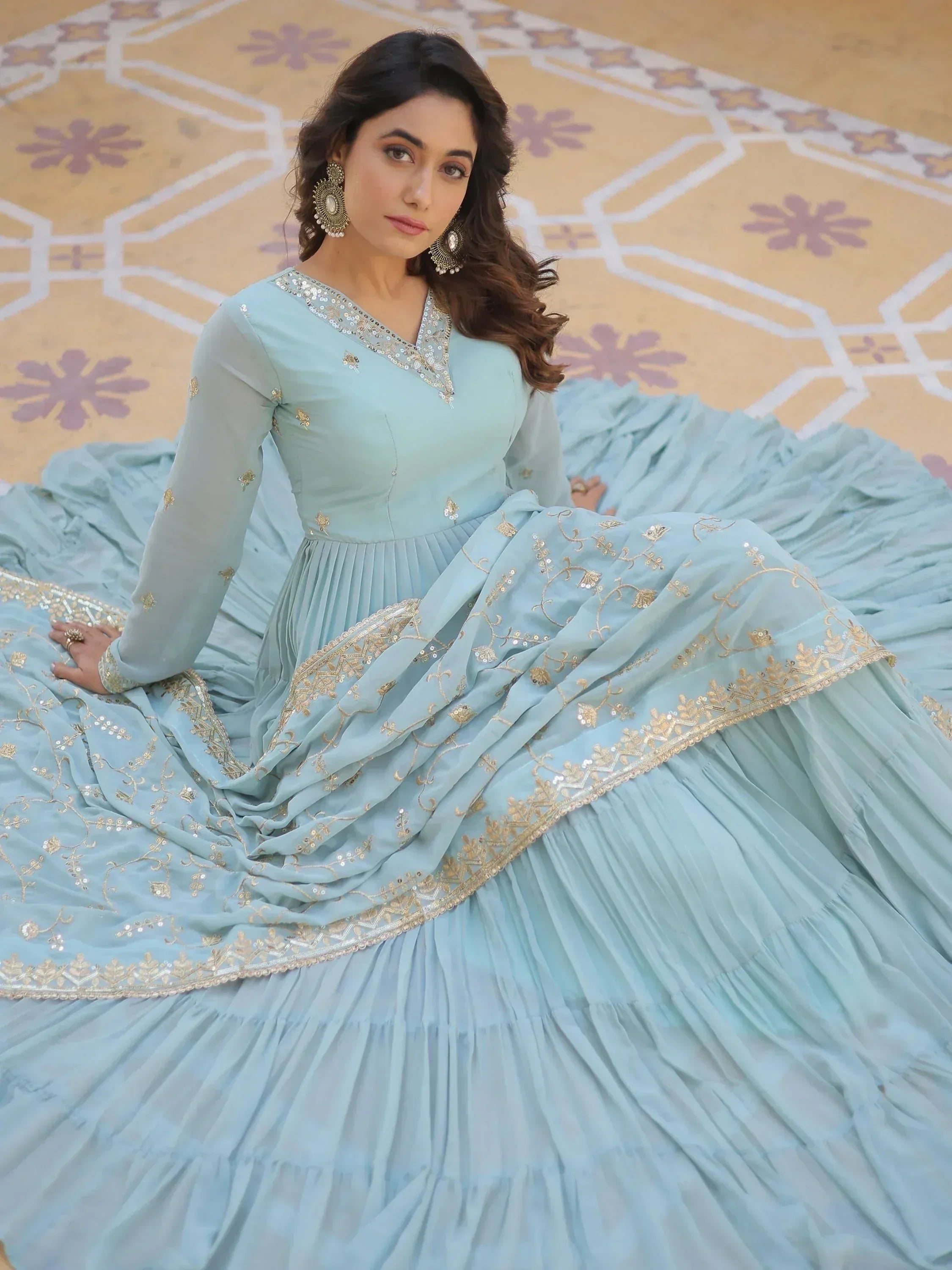 Light blue designer ethnic gown with gold embroidery and sequins, perfect for Indian weddings and parties.