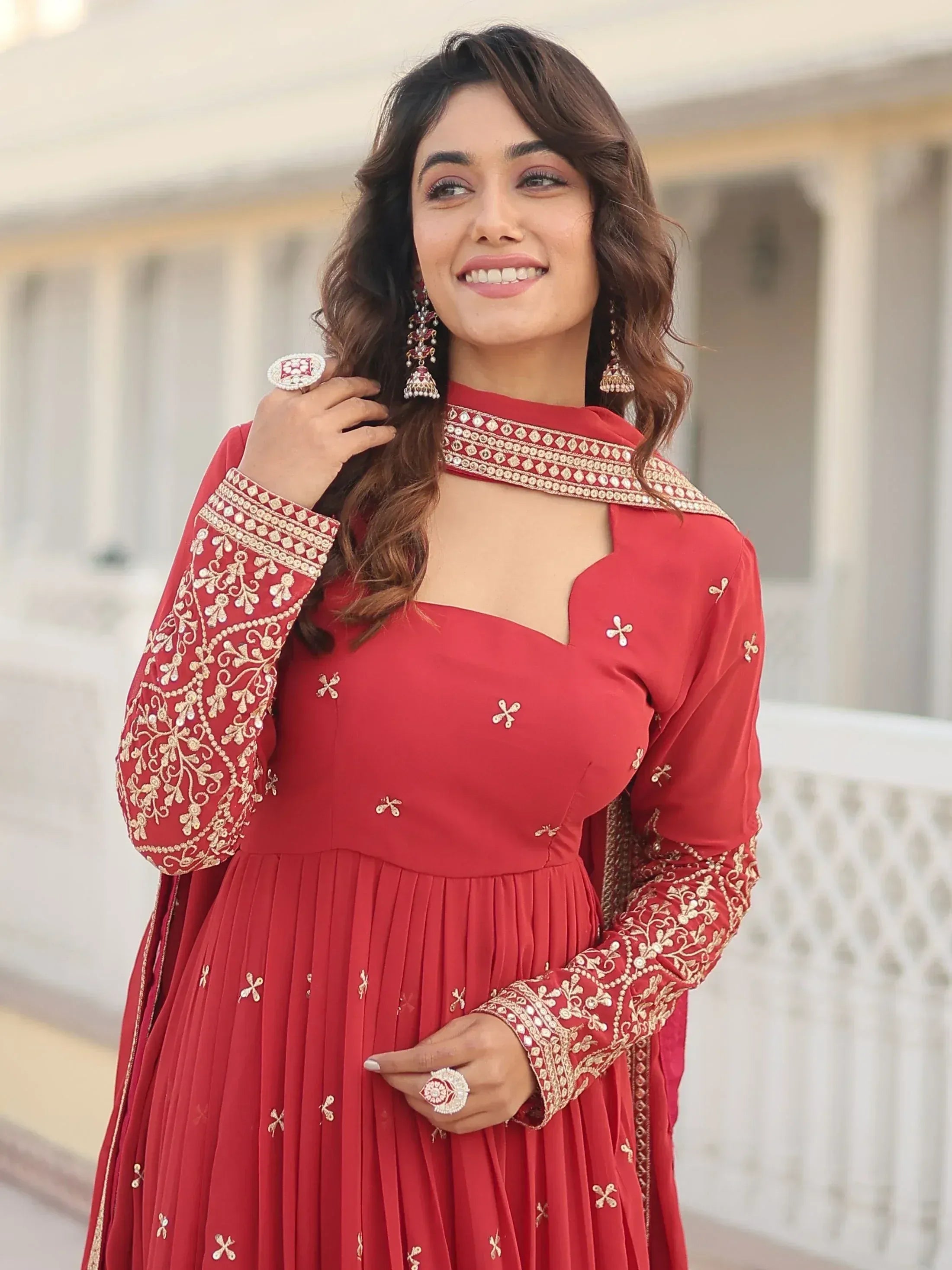 Red embroidered ethnic gown with gold detailing, perfect for Indian celebrations and festive occasions.