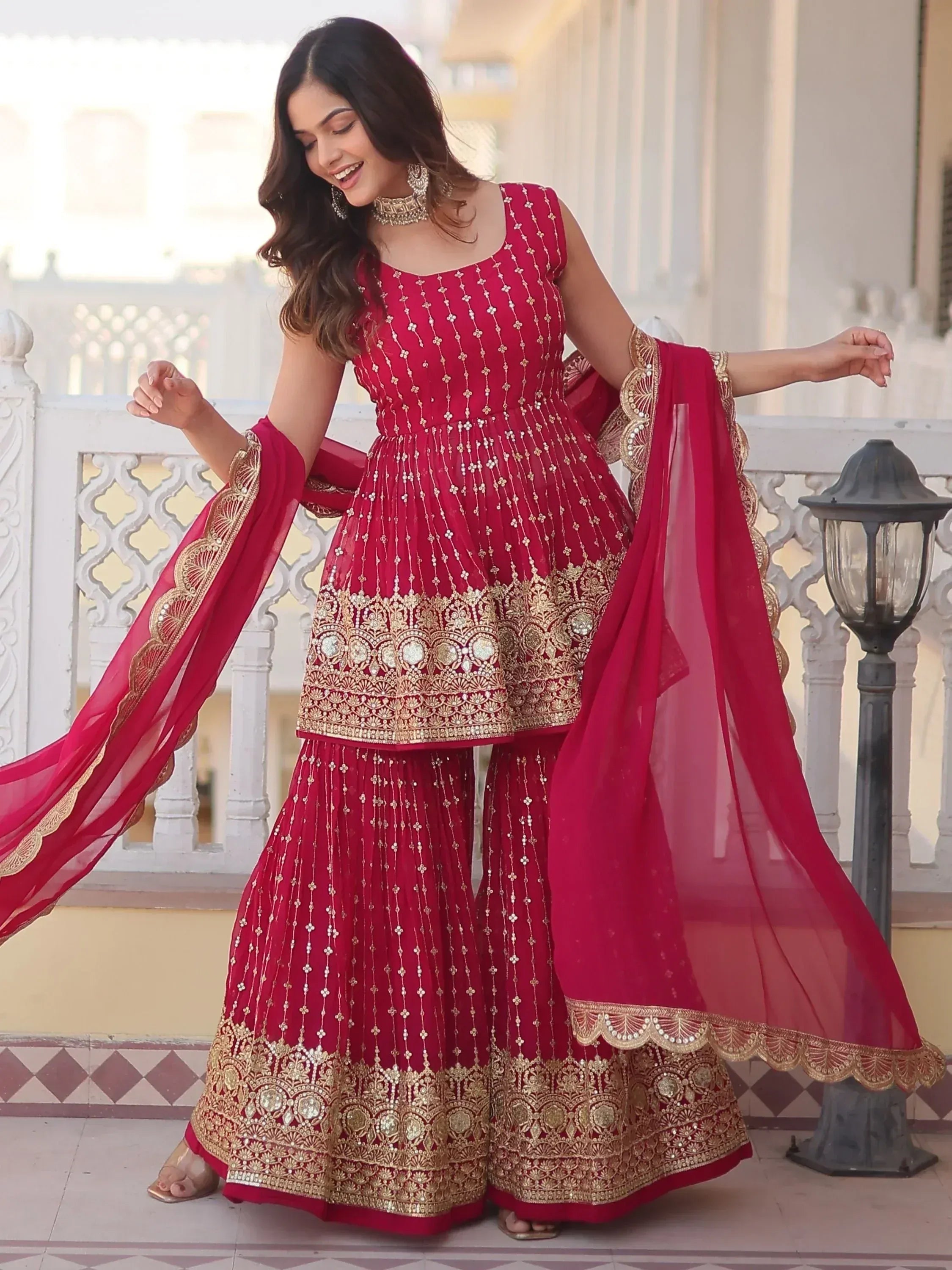 Red embroidered Indian sharara suit with gold detailing, perfect for weddings and festive occasions