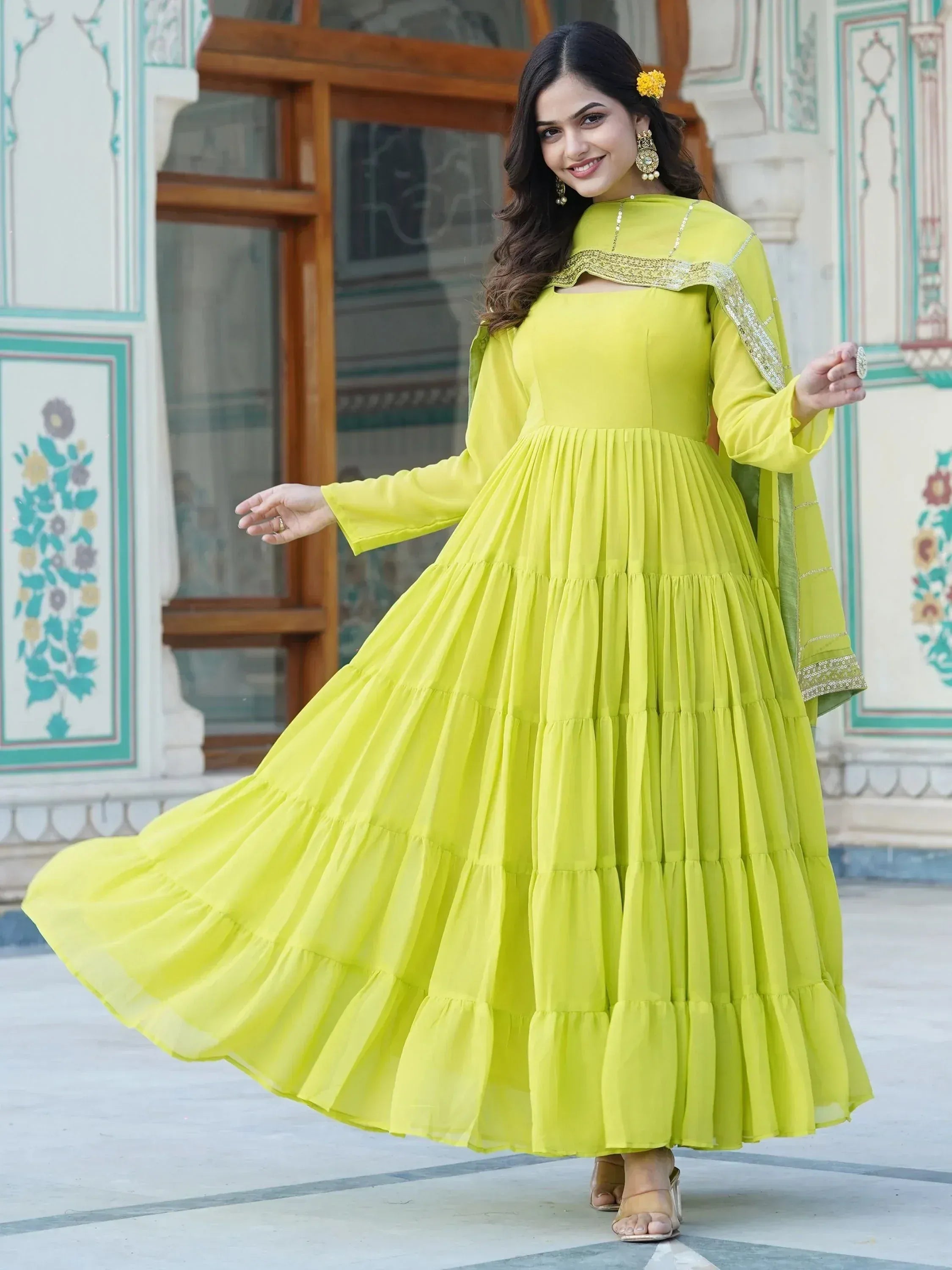 Vibrant yellow tiered ethnic gown with gold embroidery, perfect for festive occasions
